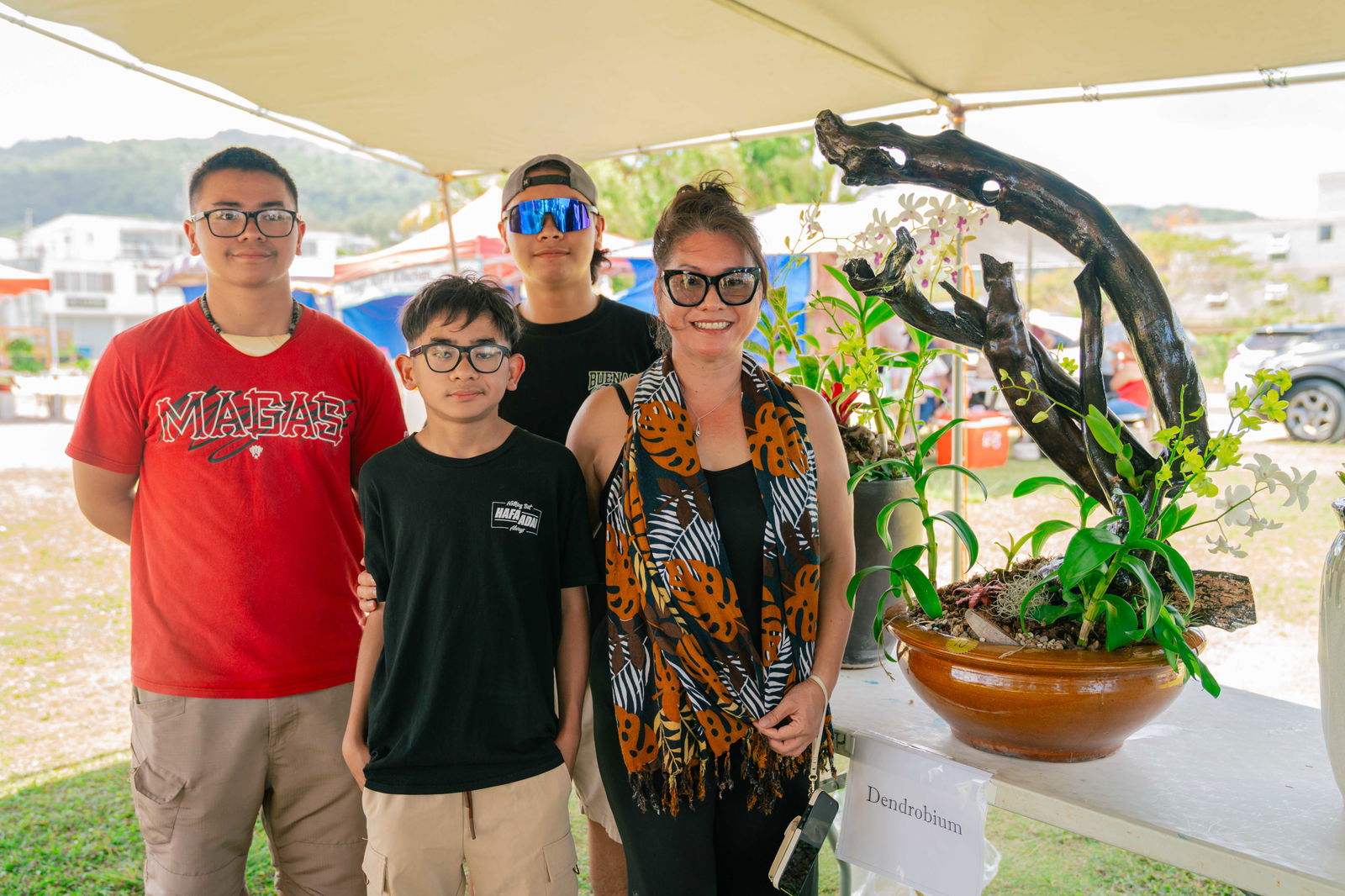 1st Place winner of the Dendrobium category Marcia Nishimura and family pose for a group photo with her winning orchid.