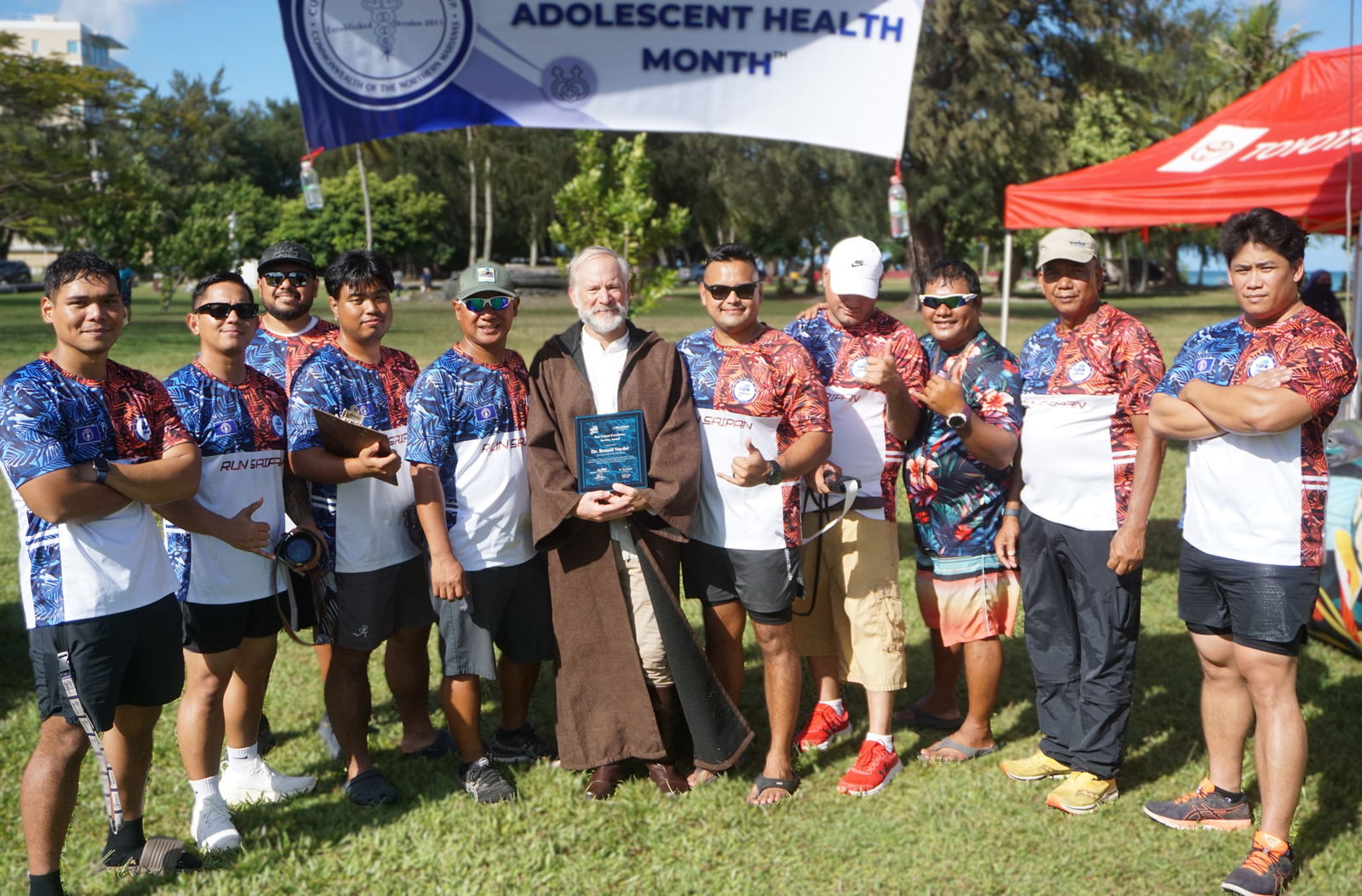 Dr. Ron Snyder, center, poses with his plaque for excellence service alongside other members of Run Saipan.  Snyder is leaving the island for good and moving to Portugal.Photo by James F. Sablan Jr.