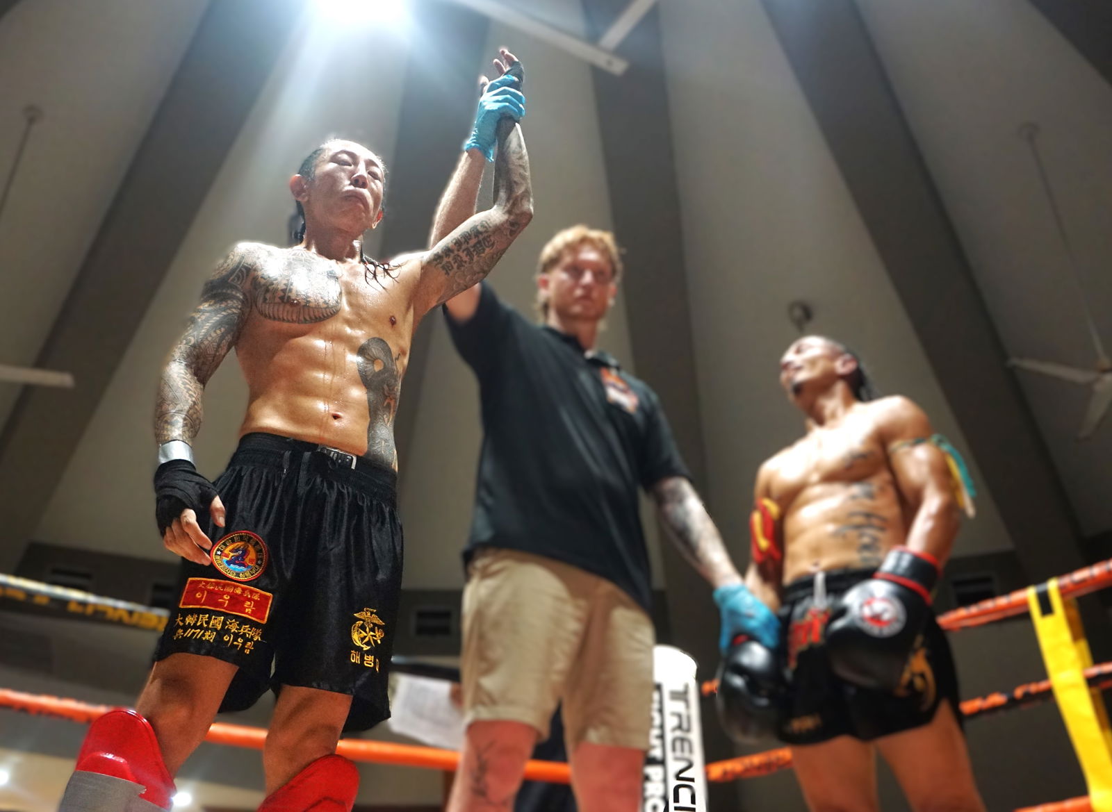 Ram Lee’s hand is raised in victory via unanimous decision over Josh Mesa in the semi-main event of Ring of Fire 3 at the Garapan Round House on Saturday night.Photo by James F. Sablan Jr.