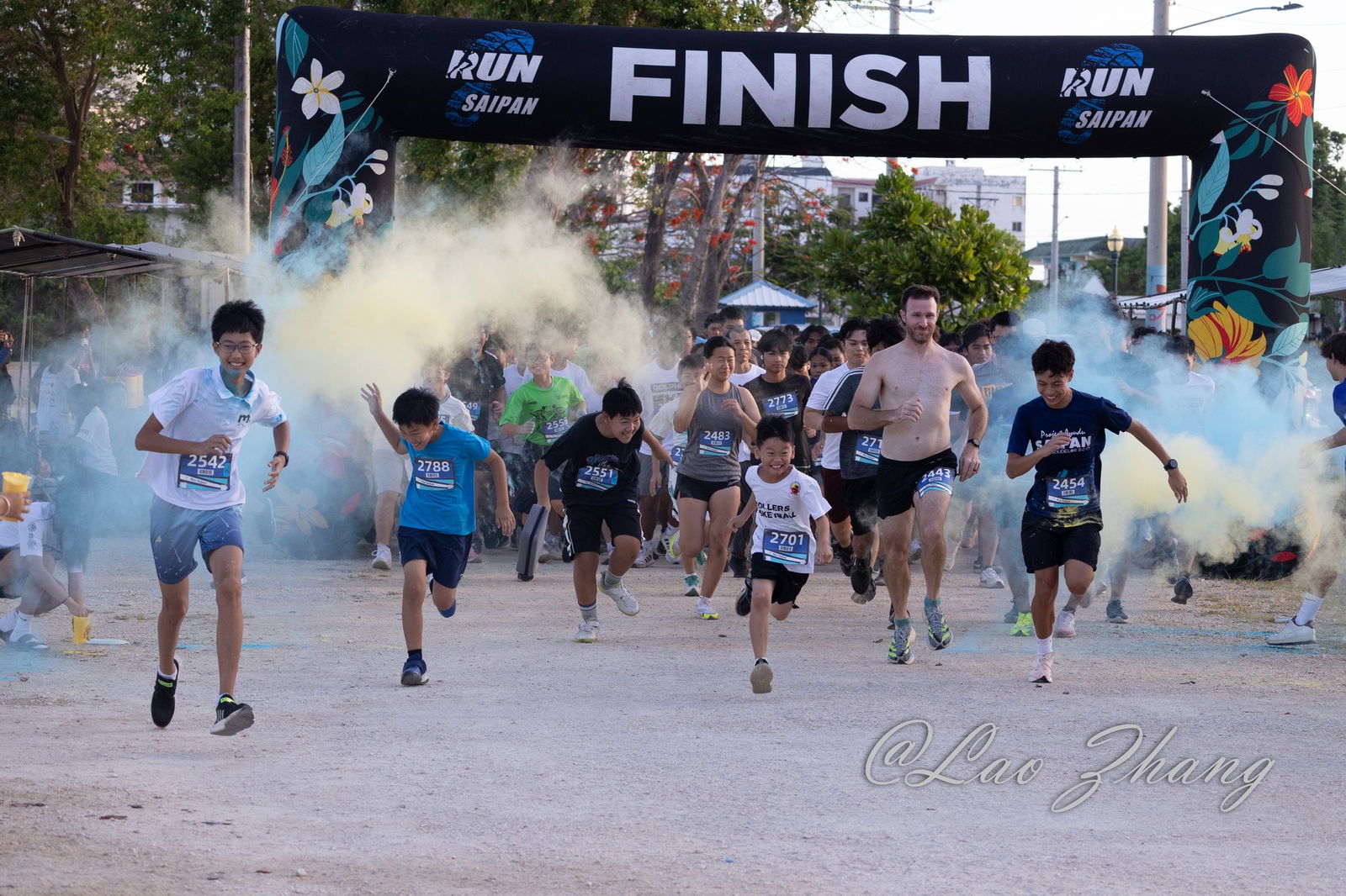 Participants are showered with colored powder as they take off from the starting line of the Dolphin 5K Fun Run on Saturday morning at the Garapan Fishing Base.