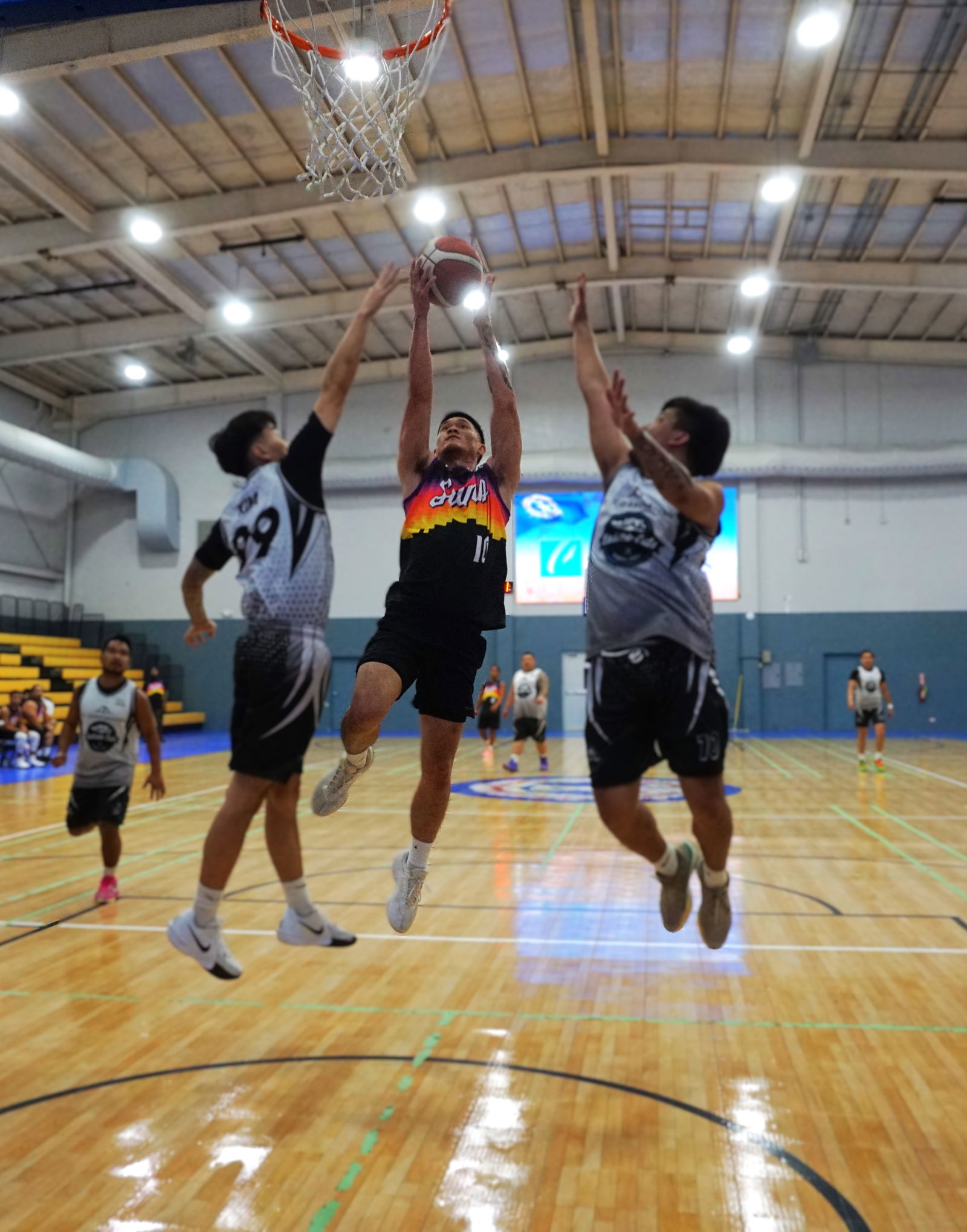 Suns’ Shane Deleon Guerrero goes up for the finish between two defenders during a game against Eastside Cuts/Elite Kuyas in the Michelob Ultra Cup 2025 at the Ada gym on Tuesday.Photo by James F. Sablan Jr.