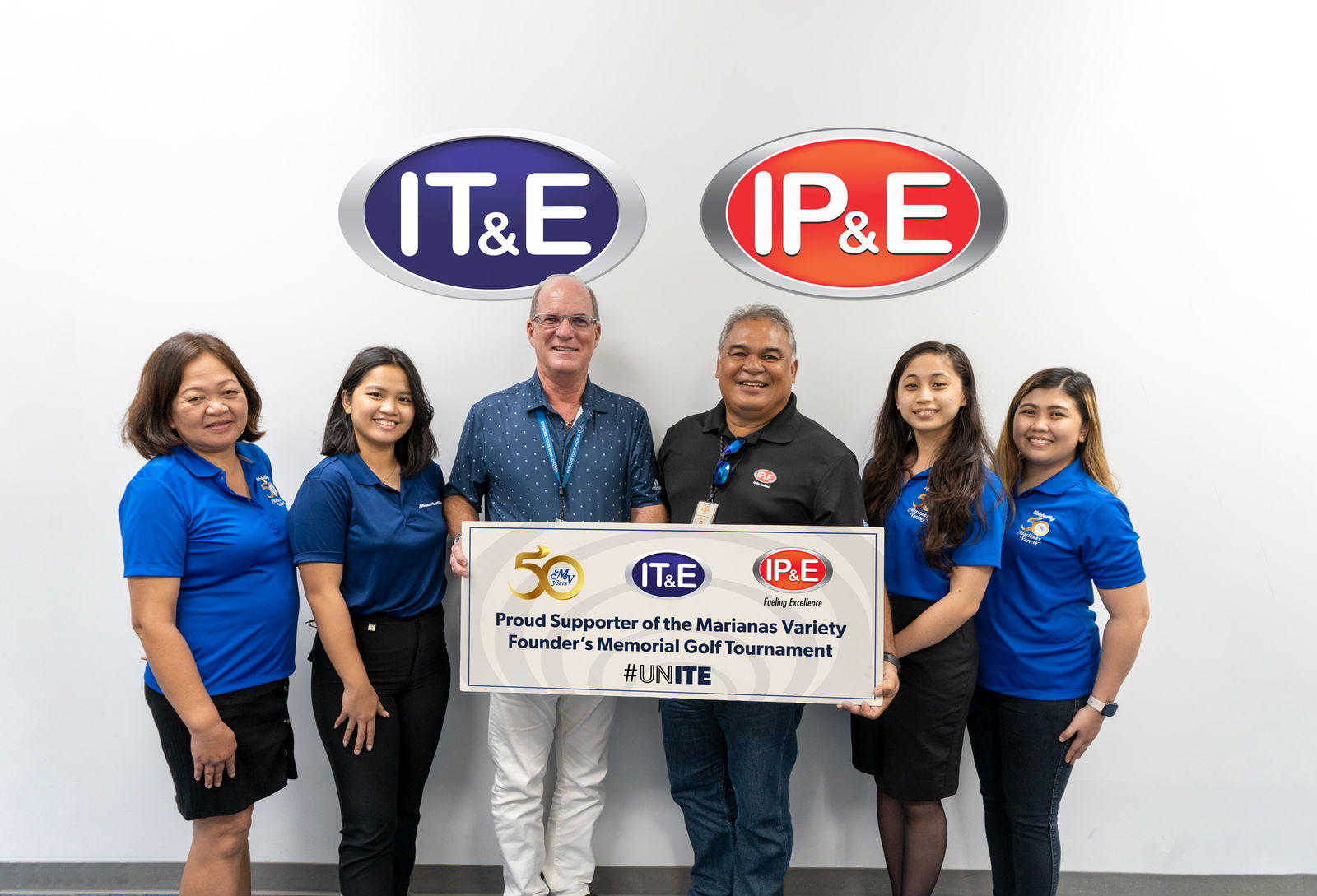 Hans Mickelson, 3rd left, IT&E enterprise business group/sales manager and Ronald T. Benavente, 3rd right, IP&E commercial accounts manager, pose for a photo with Marianas Variety sales representatives Jeanette Sarabia, Hazel Sadian, Monique Mascarinas and Gwendolyn Sandig. IT&E and IP&E are among the supporters of the MV Founder's Memorial Golf Tournament  which aims to raise funds for the charitable organization Karidat. The event will be held Saturday, April 2 at 6 a.m., LaoLao Bay Golf & Resort, West Course.