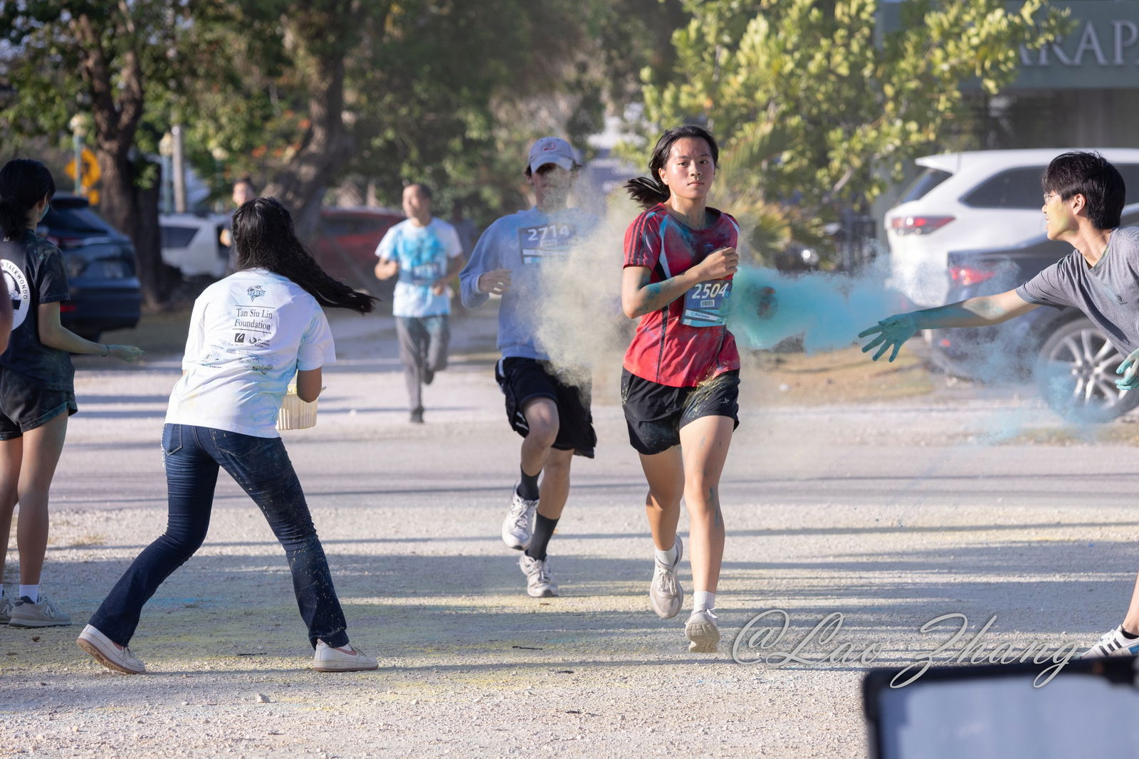Jiahui Chen nears the finish line in a cloud of colored powder.