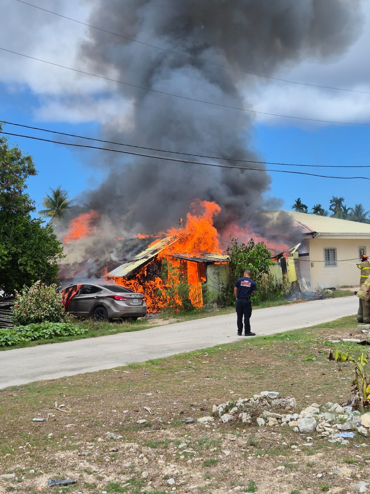 Firefighters respond to a blaze that engulfed a wood-and-tin house Friday in Chalan Kanoa.