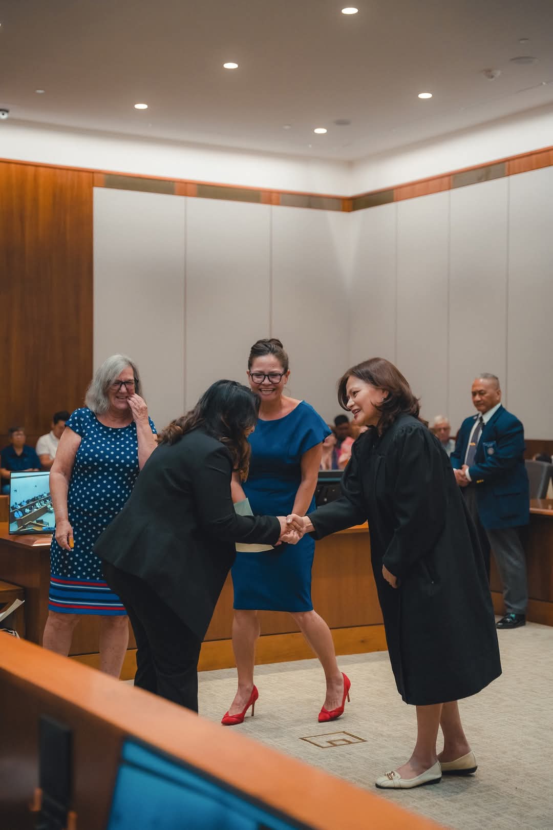 Chief Judge Ramona V. Manglona of the District Court for the NMI congratulates a new U.S. citizen while U.S. Congresswoman Kimberlyn King-Hinds and USCIS Officer Patricia Phelan look on.
