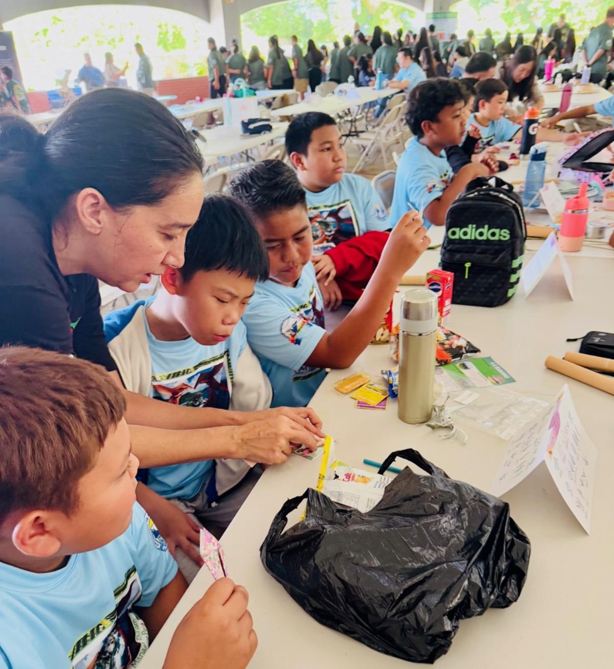 Students of school MY WAVE — or Marianas Youth Welcome All Visitors Enthusiastically —  Clubs learn to make paper cranes during the Marianas Tourism Education Council Tourism Summit on Jan. 24, 2025, at Garapan Central Park in Saipan, The Marianas. Students folded a traditional Japanese “senbazuru” — 1,000 origami cranes — to mark 80 years of peace in The Marianas since World War II.