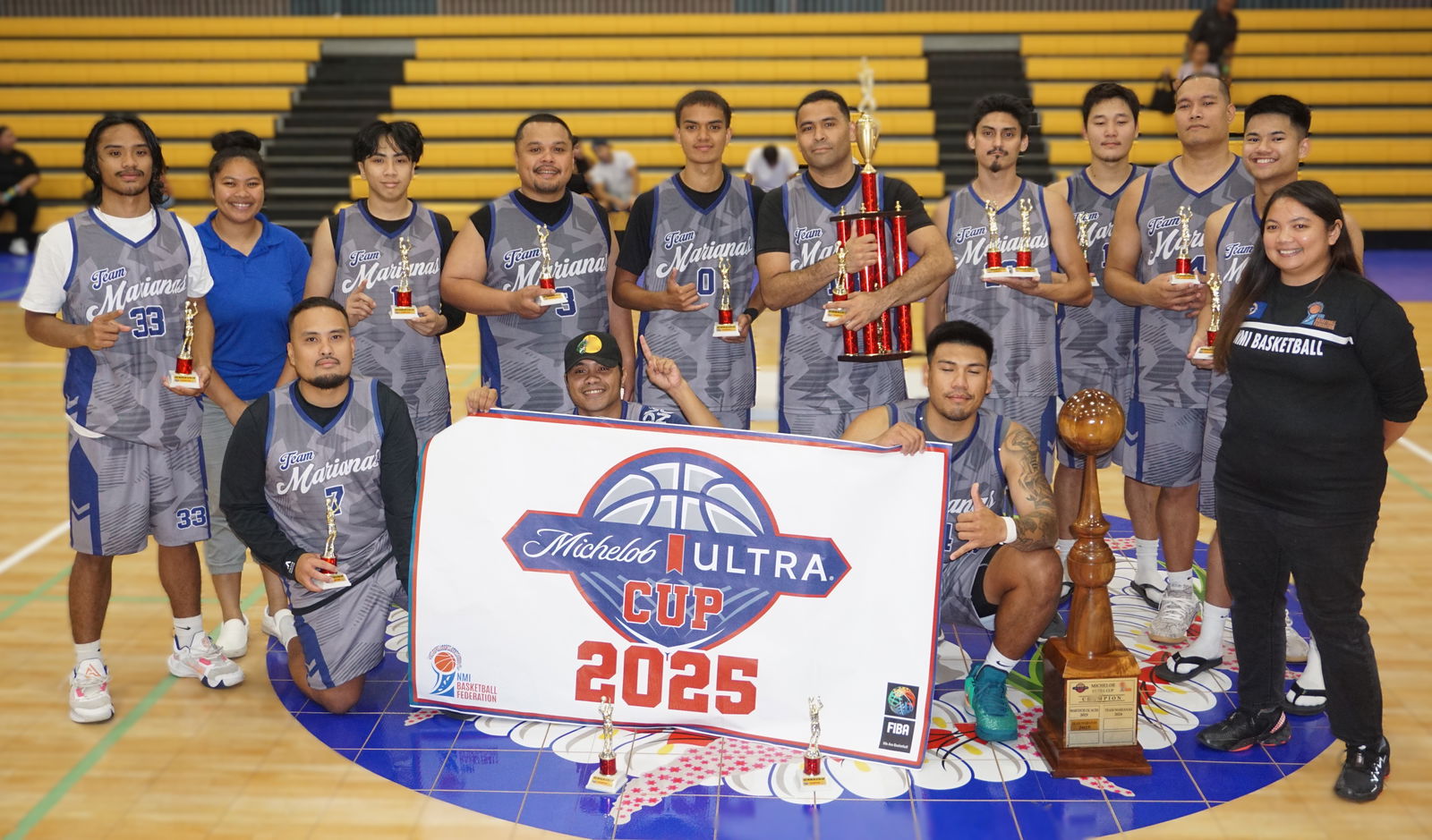 Team Marianas players pose with the 2025 Michelob Ultra Cup championship trophies after successfully defending their title against Unity Trade, 94-84, on Wednesday at the Ada gym.Photo by James F. Sablan Jr.