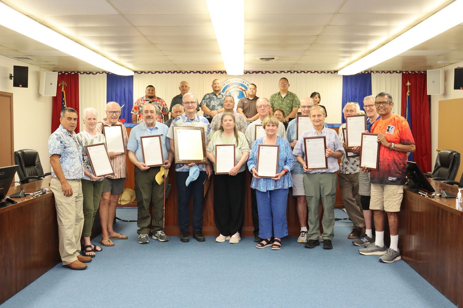 Members of the CNMI House of Representatives and the Senate pose for a photo with visiting former Peace Corps volunteers, who received copies of House Resolution 24-07. The resolution, which was adopted by the House, honors the volunteers for their service to the people of the Northern Marianas that began in the mid-1960s. Legislative Bureau photo