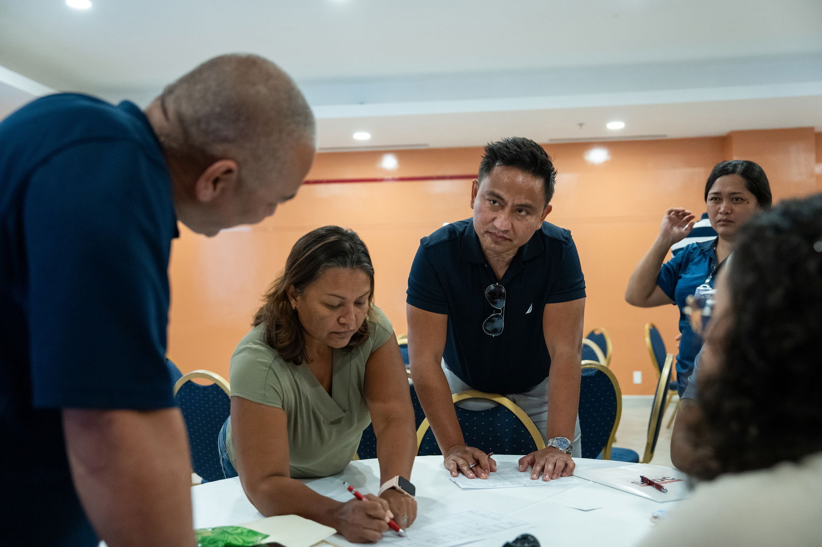 Participants work on a group activity where groups had to trade stocks between each other utilizing best practice mitigation strategies.