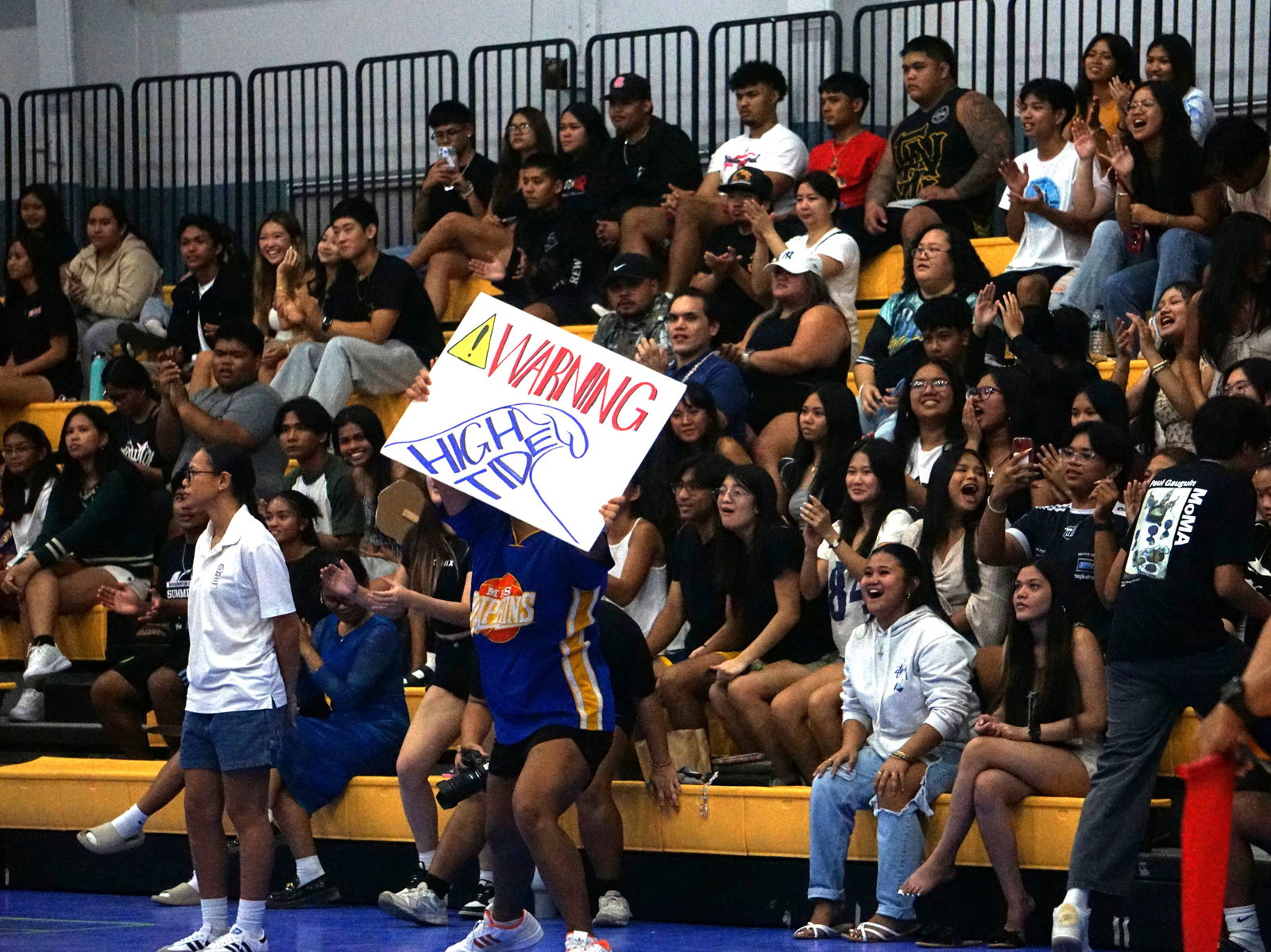 Fans of Marianas High School celebrate after the team won a set.