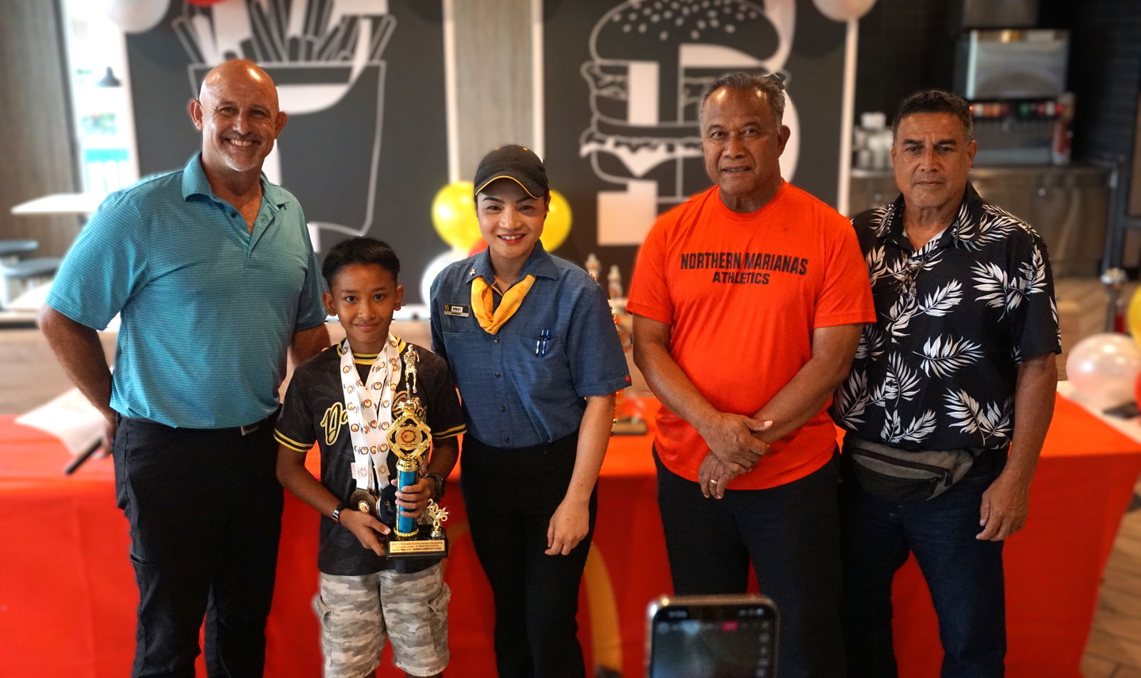 12U boys MVP, Kagman Elementary School's Daviray Indalecio, poses for a photo with PSS Athletics Program Director Nick Gross, McDonald's Middle Road acting general manager Angelica Darlucio, Northern Marianas Athletics President Ray Tebuteb, and longtime national coach Rep. Elias Rangamar.Photo by James F. Sablan Jr.