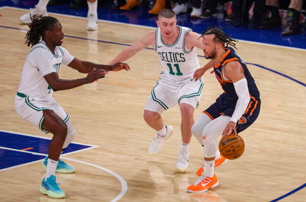 New York Knicks guard Jalen Brunson (11) dribbles against Boston Celtics guard Payton Pritchard (11) and Jrue Holiday (4) in the second half during game four of the second round for the 2025 NBA Playoffs at Madison Square Garden in New York on May 12, 2025.Photo by Vincent Carchietta-Imagn Images