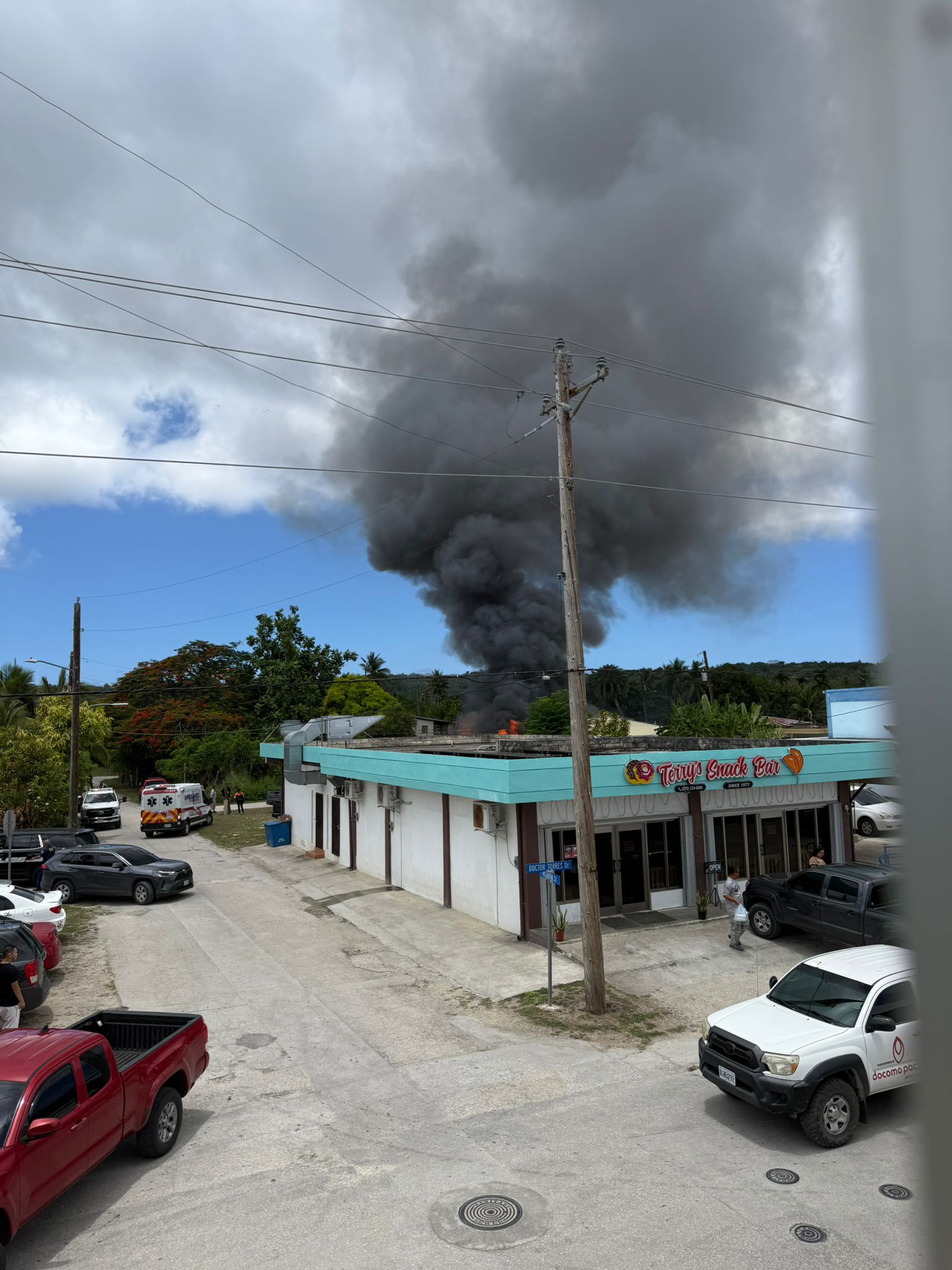 Thick, heavy black smoke is seen rising behind Terry’s Snack Bar in Chalan Kanoa around noon on Friday.