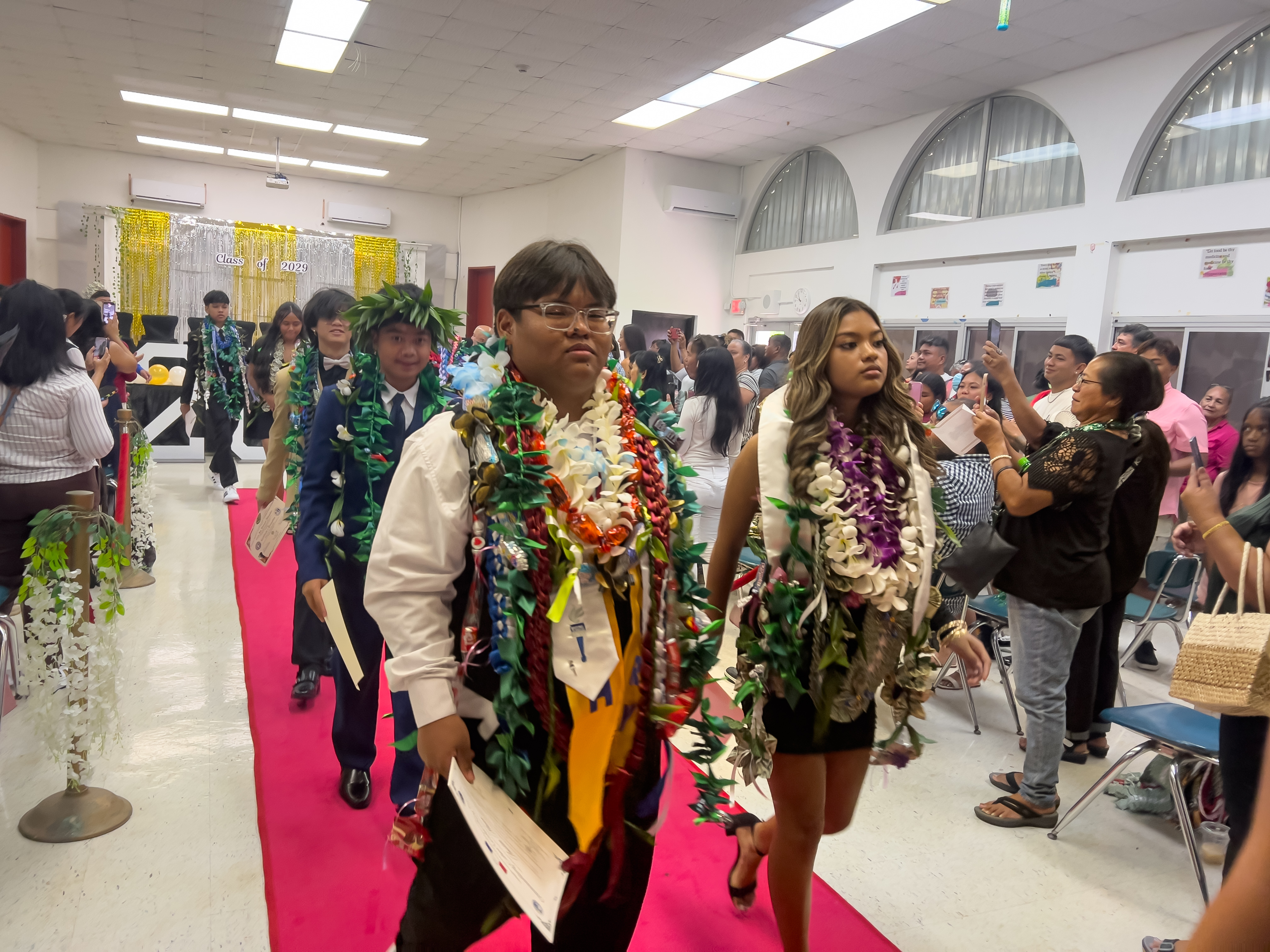 The promoted Tinian Middle School students exit the cafeteria at the conclusion of their promotion ceremony.