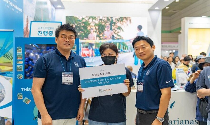 LaoLao Bay Golf & Resort Sales Manager Joe Jo, right, and Saipan LauLau Korea Inc. Managing Director Ma Tong-Young present a hotel night stay gift certificate to a raffle winner at the Marianas Visitors Authority booth at the Seoul International Travel Fair held on June 5-8, 2025, in South Korea. The fair attracted over 45,000 attendees.