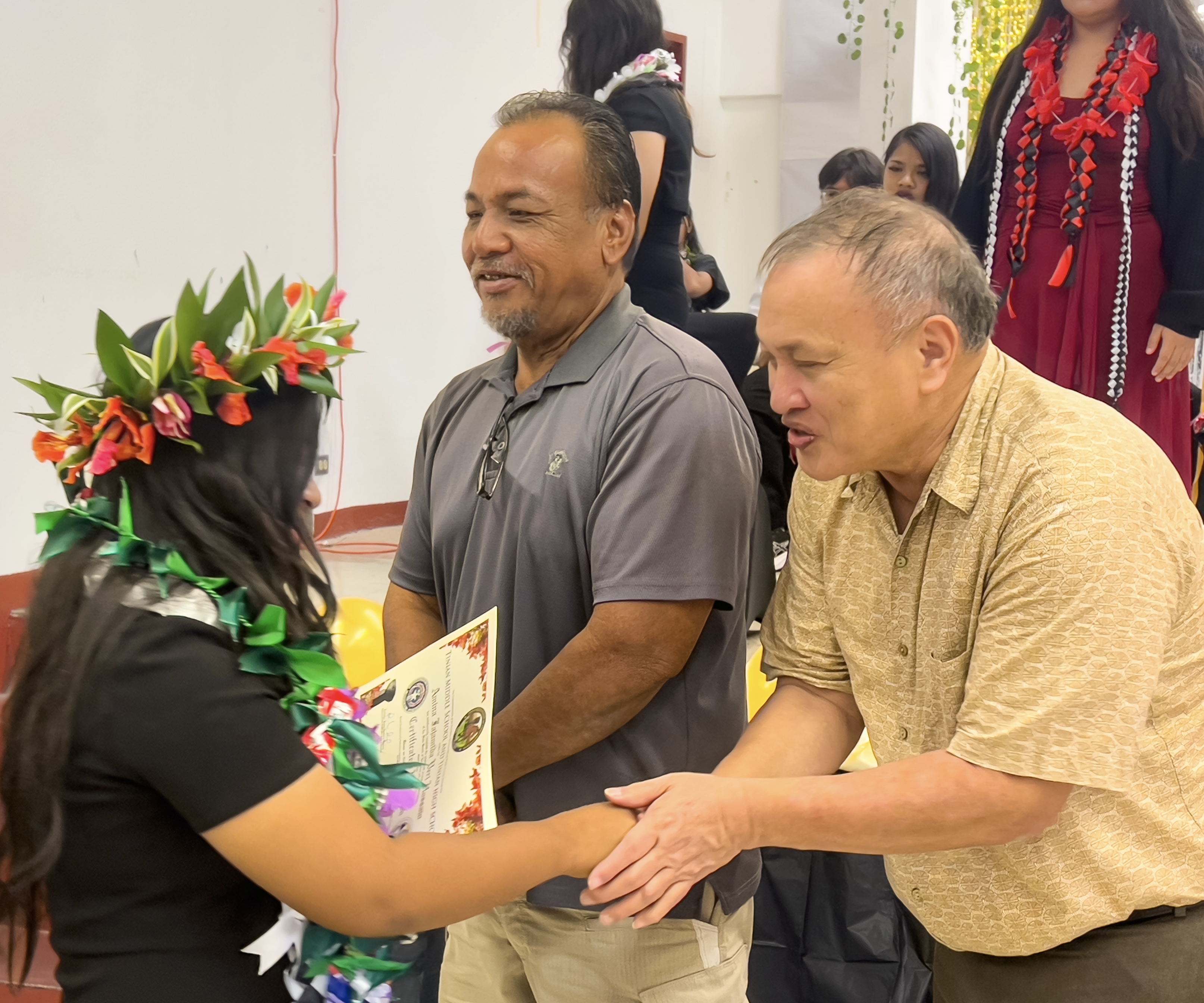 BOE Member Andrew L. Orsini congratulates class valedictorian Amina Fajamida Vera Hossain as BOE Vice Chairman Anthony DLC Barcinas smiles.