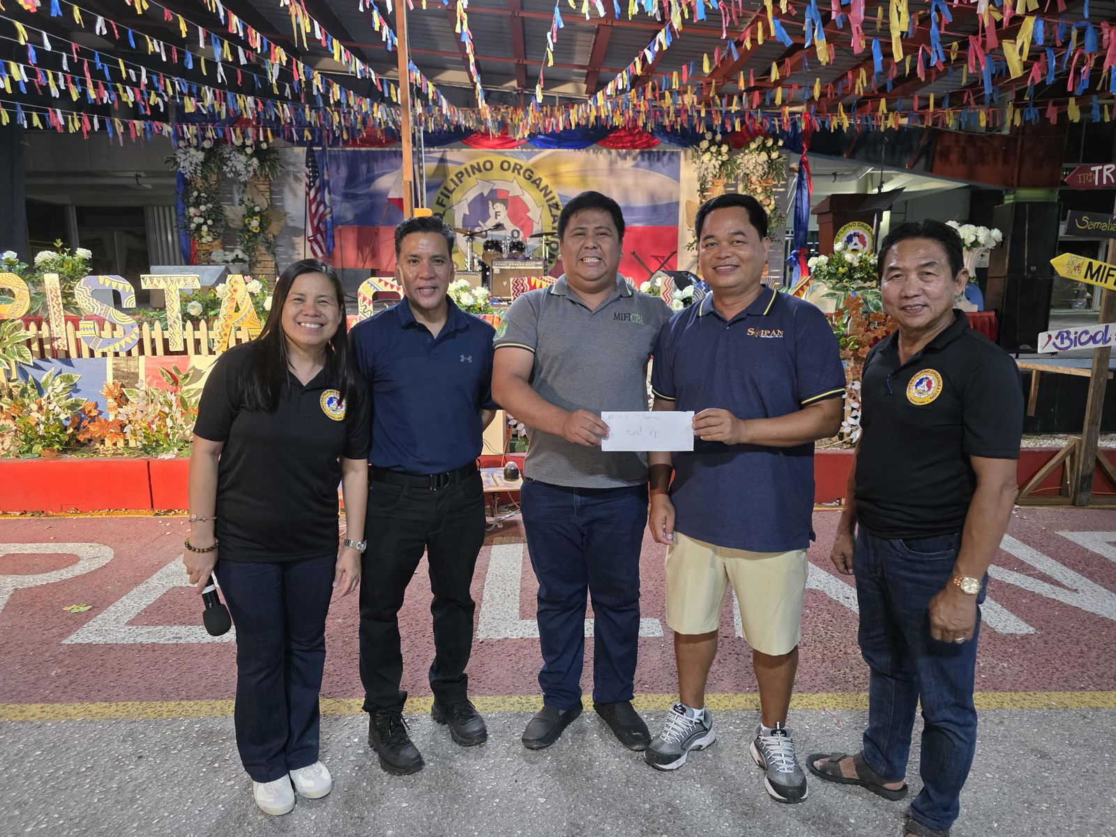 Marcelo Masilungan of Supertech presents Marvin Buston, the grand prize winner in the 2025 Pistang Pinoy raffle, a round-trip ticket to Manila. Also in photo are United Filipino Organizations President Carlito Marquez, Eloisa Manese and Philippine Consul to Guam Joaquin Ricardo Aragon.Photo by Bryan Manabat