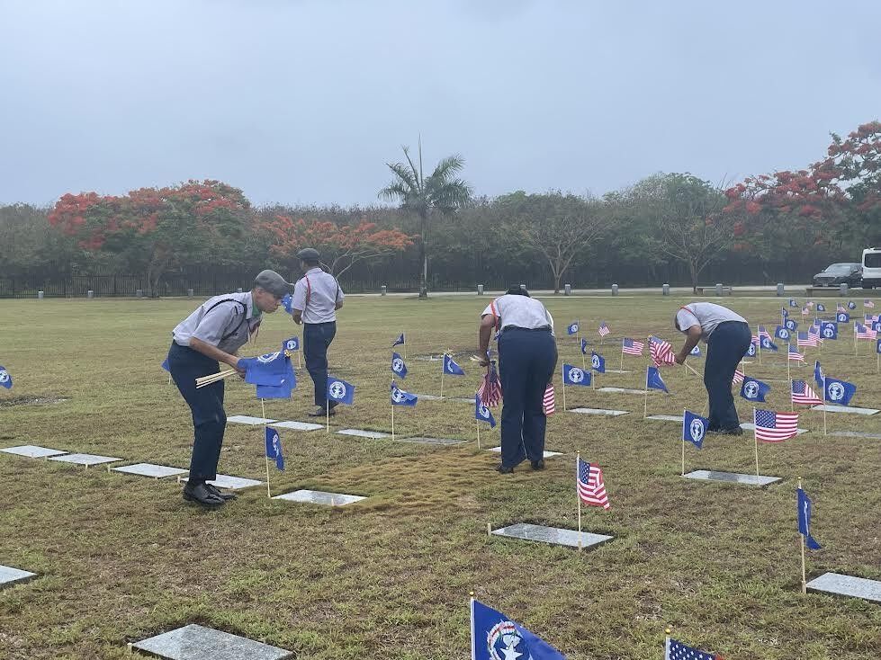Manta Ray cadets place individual U.S. and CNMI flags on the gravestones of fallen heroes.