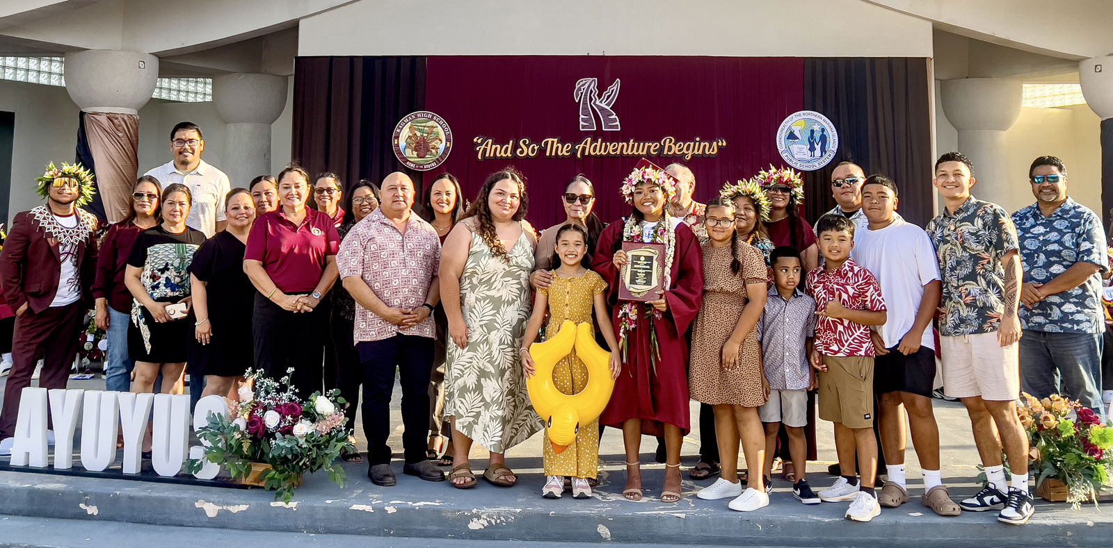Class salutatorian Pia Helen Edangel Sablan Ngewakl poses for a photo with her family after receiving the Commissioner of Education Academic Excellence Award from Commissioner of Education Dr. Lawrence F. Camacho and other PSS officials. Also in photo are BOE members.