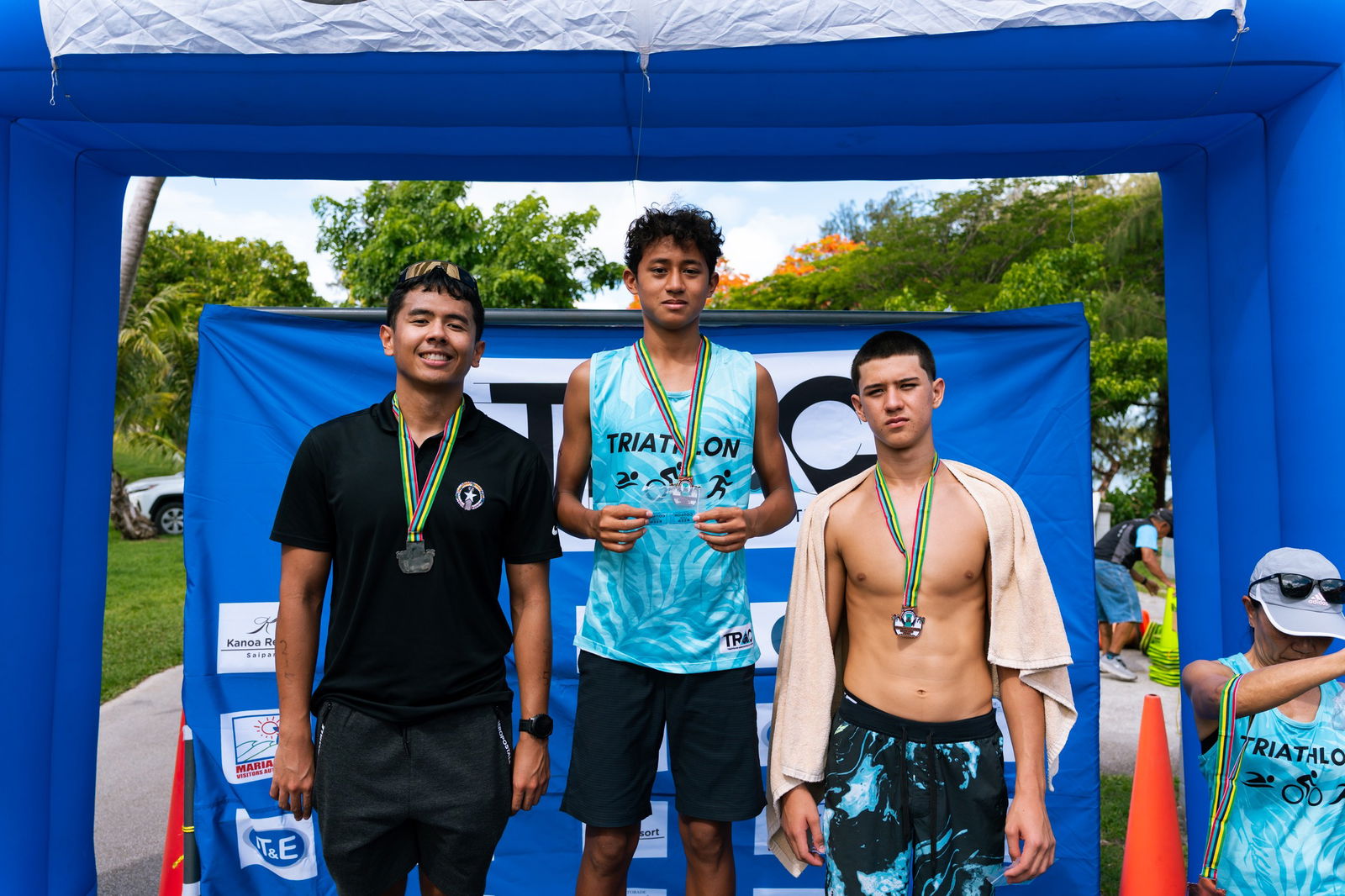 Takeru Jim, Christian Villacrusis, and Michael Miller pose as the top three finishers in the men's division of the Triathlon Association of the CNMI's "Just Tri-It" triathlon at Paupau Beach on Saturday.