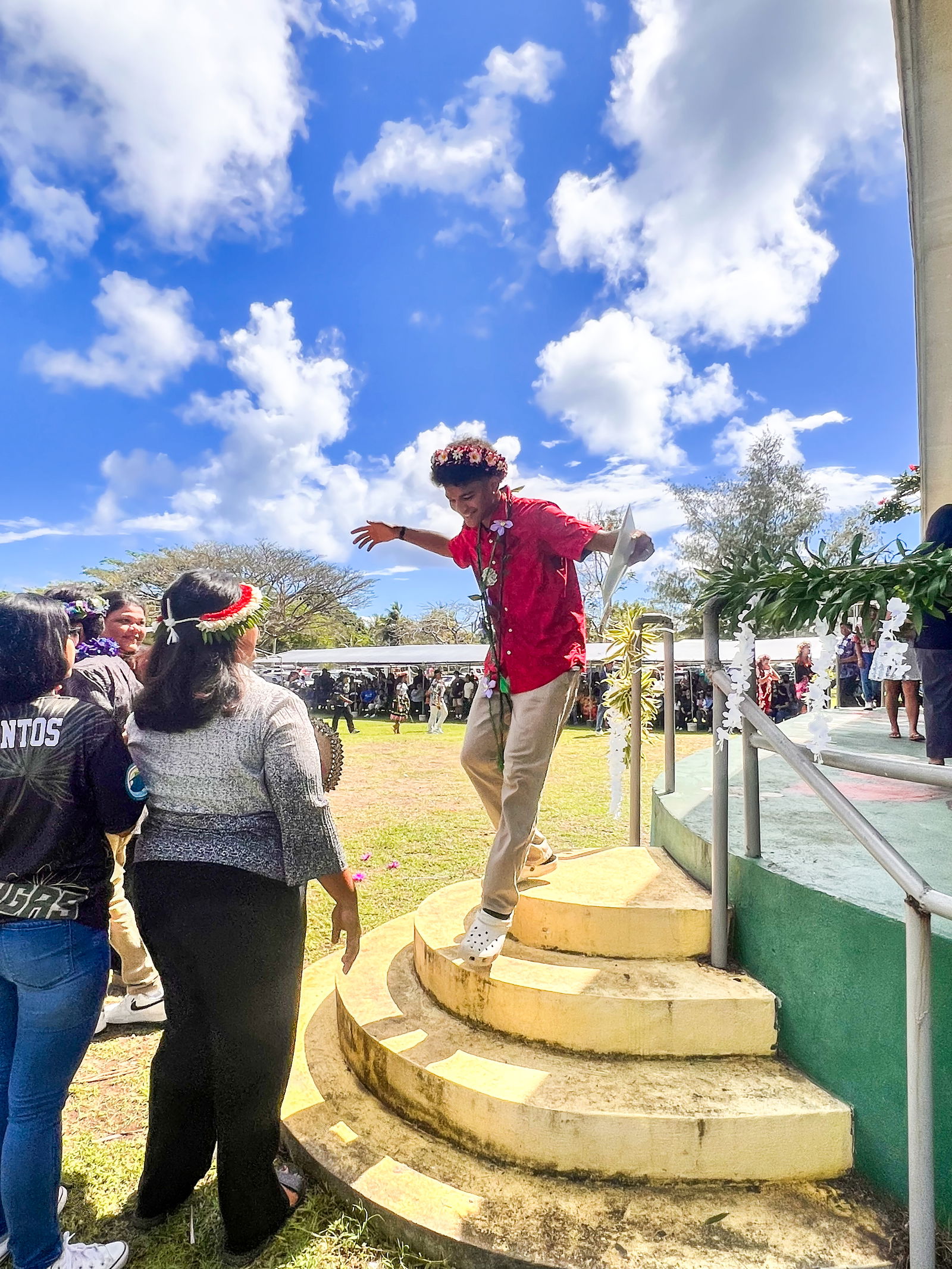 A jubilant promoted student is greeted by his teachers as he descends from the stage.