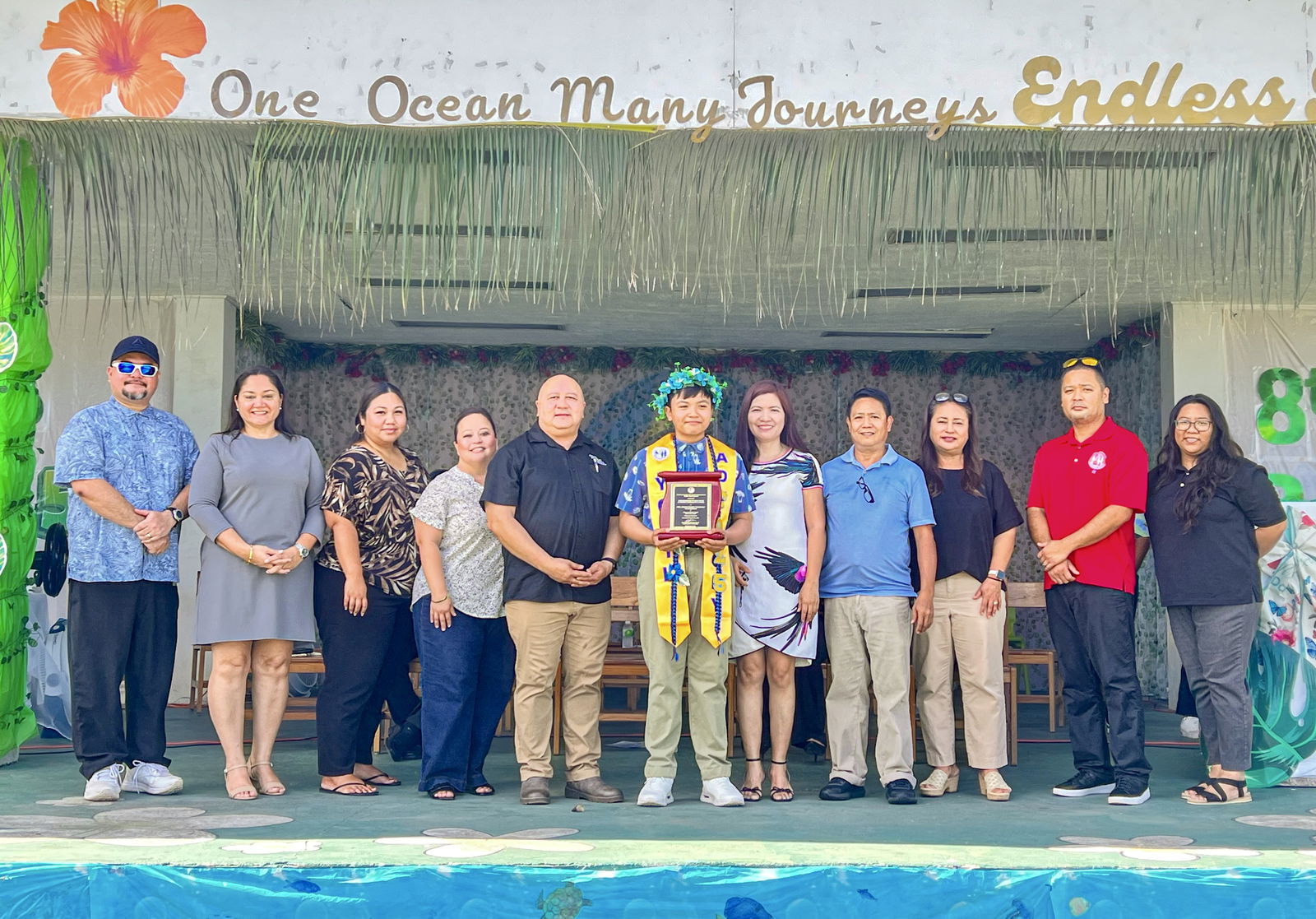 Salutatorian Neil Josiah Cunanan, center, with his parents, Commissioner of Education Dr. Lawrence F. Camacho and other PSS managers