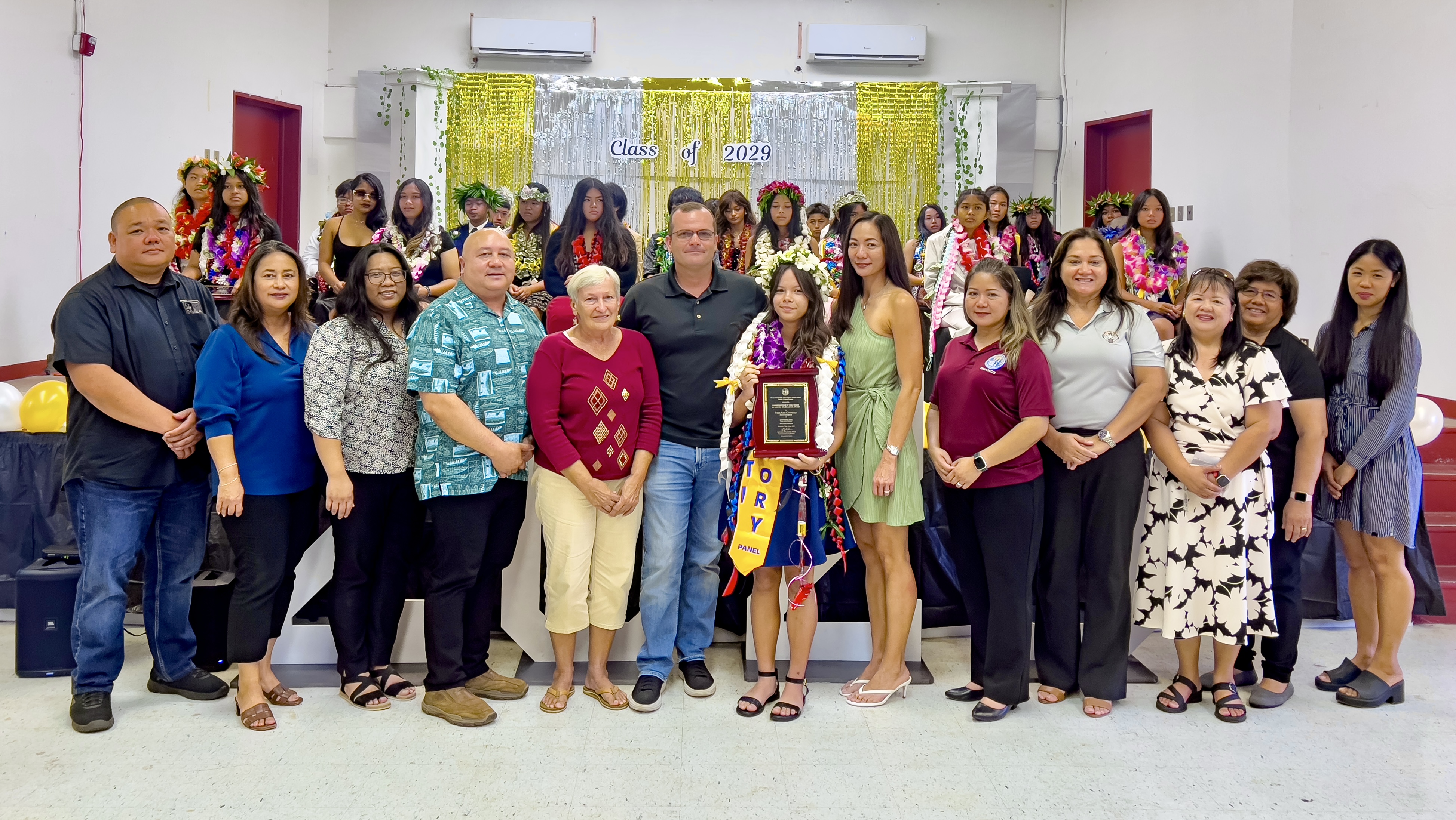 Class salutatorian and recipient of the Commissioner of Education Academic Excellence Award Piper Rose Christian poses for a photo with her family, Commissioner of Education Dr. Lawrence F. Camacho and other PSS officials.