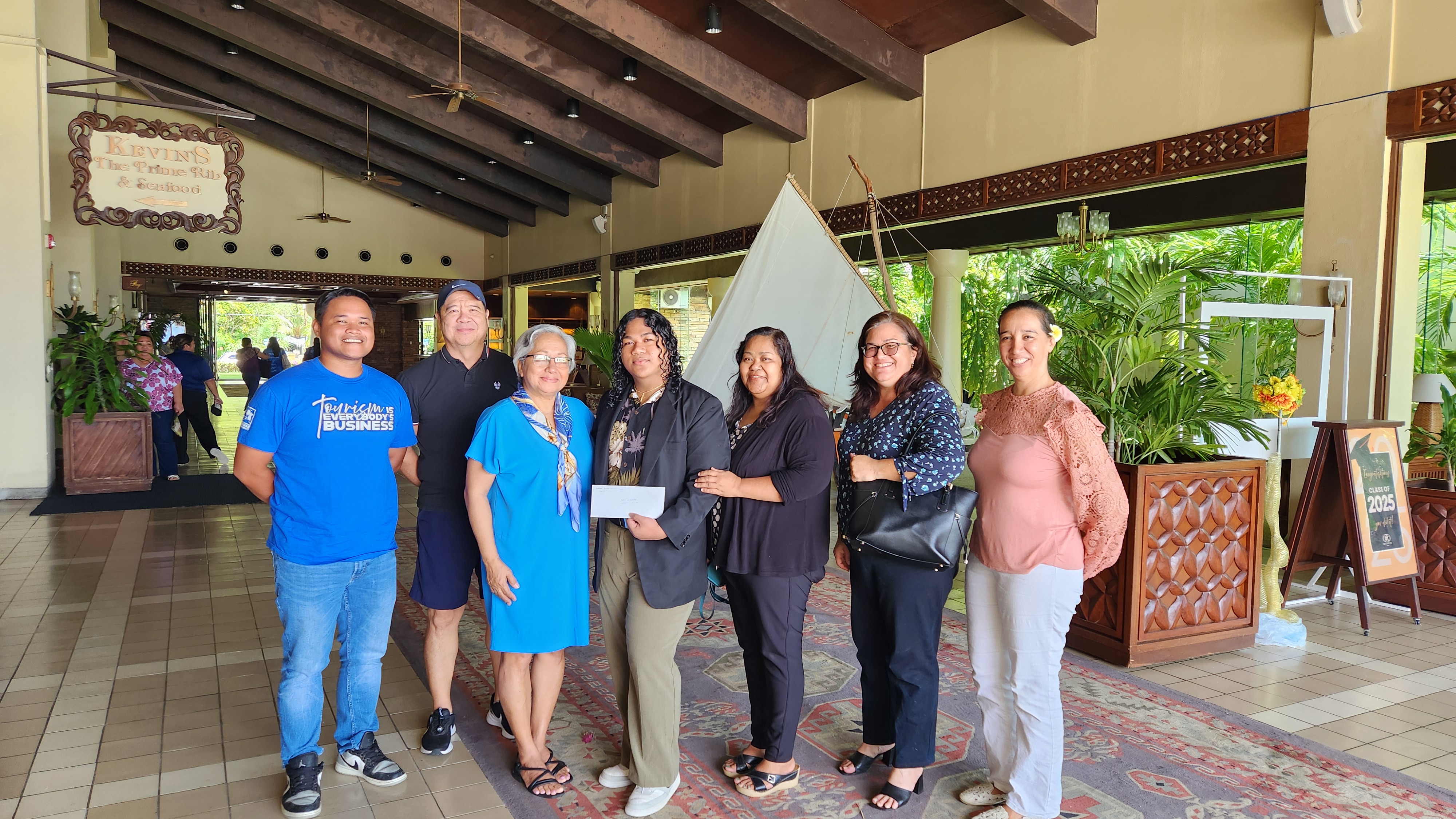 Kagman High School graduate Davin Nekaifes, center, receives a $1,000 scholarship from the Marianas Tourism Education Council on June 13, 2025, at Aqua Resort Club Saipan in San Roque, Saipan. From left, Marianas Visitors Authority Community Project Coordinator Jack Aranda, MVA Community Projects Manager and MTEC Secretary Martin Duenas, MTEC Board Chairwoman Benavente, Nekaifes, Zina Nekaifes, MTEC Treasurer Larrisa Larson, and MTEC Board Member Catherine Perry.MVA photo