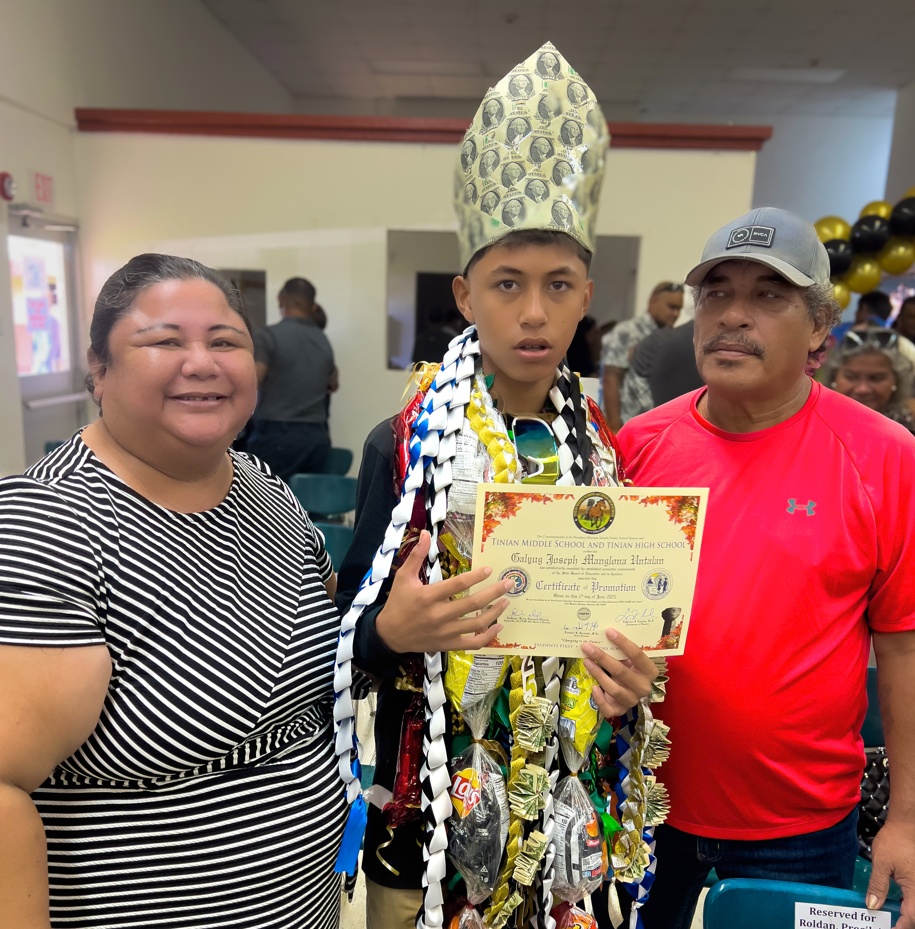 Tinian Elementary School Principal Lou Connie Manglona poses with her promoted son, Galyug Untalan, and his father, Marcus.