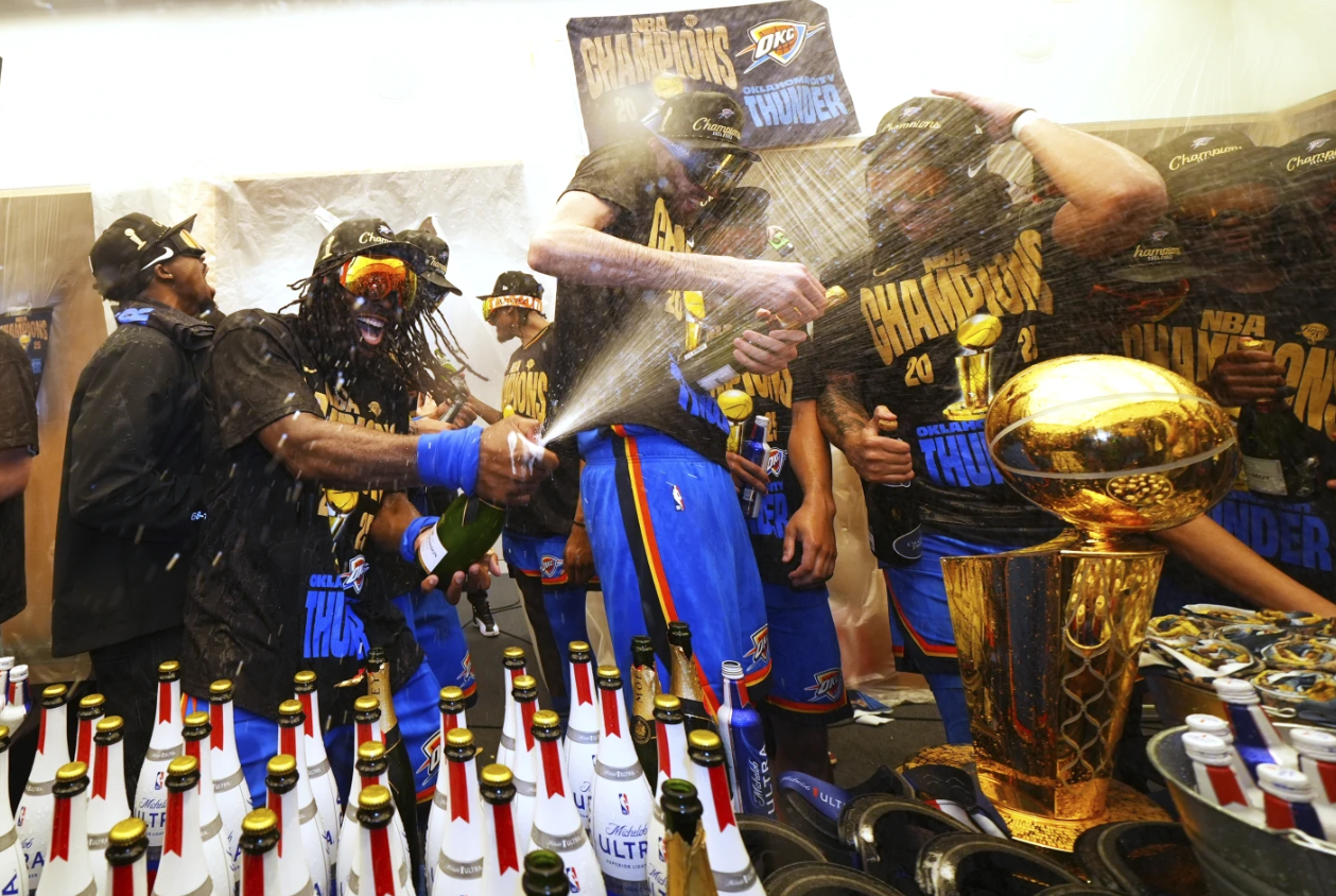 Oklahoma City Thunder guard Luguentz Dort, left, celebrates with teammates in the locker room after winning the NBA championship with a Game 7 victory against the Indiana Pacers on Sunday, June 22, 2025 in Oklahoma City.AP