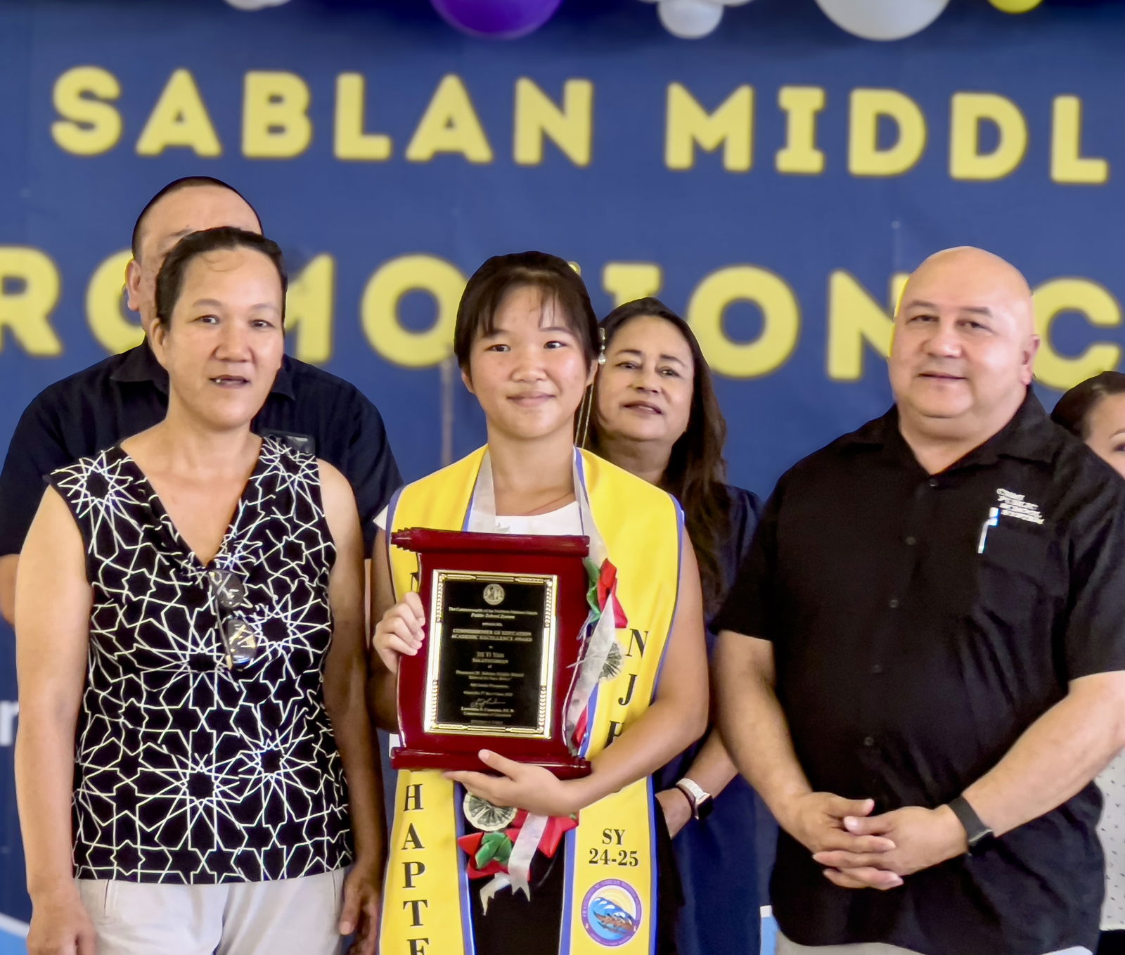 Commissioner of Education Dr. Lawrence F. Camacho, right, poses with FMS class salutatorian Jie Yi Yan and her mother.