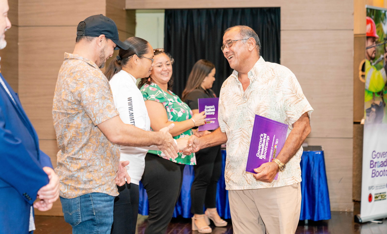 A graduate of the Governor’s Broadband Bootcamp shakes hands with Bootcamp instructor Christian Camacho.