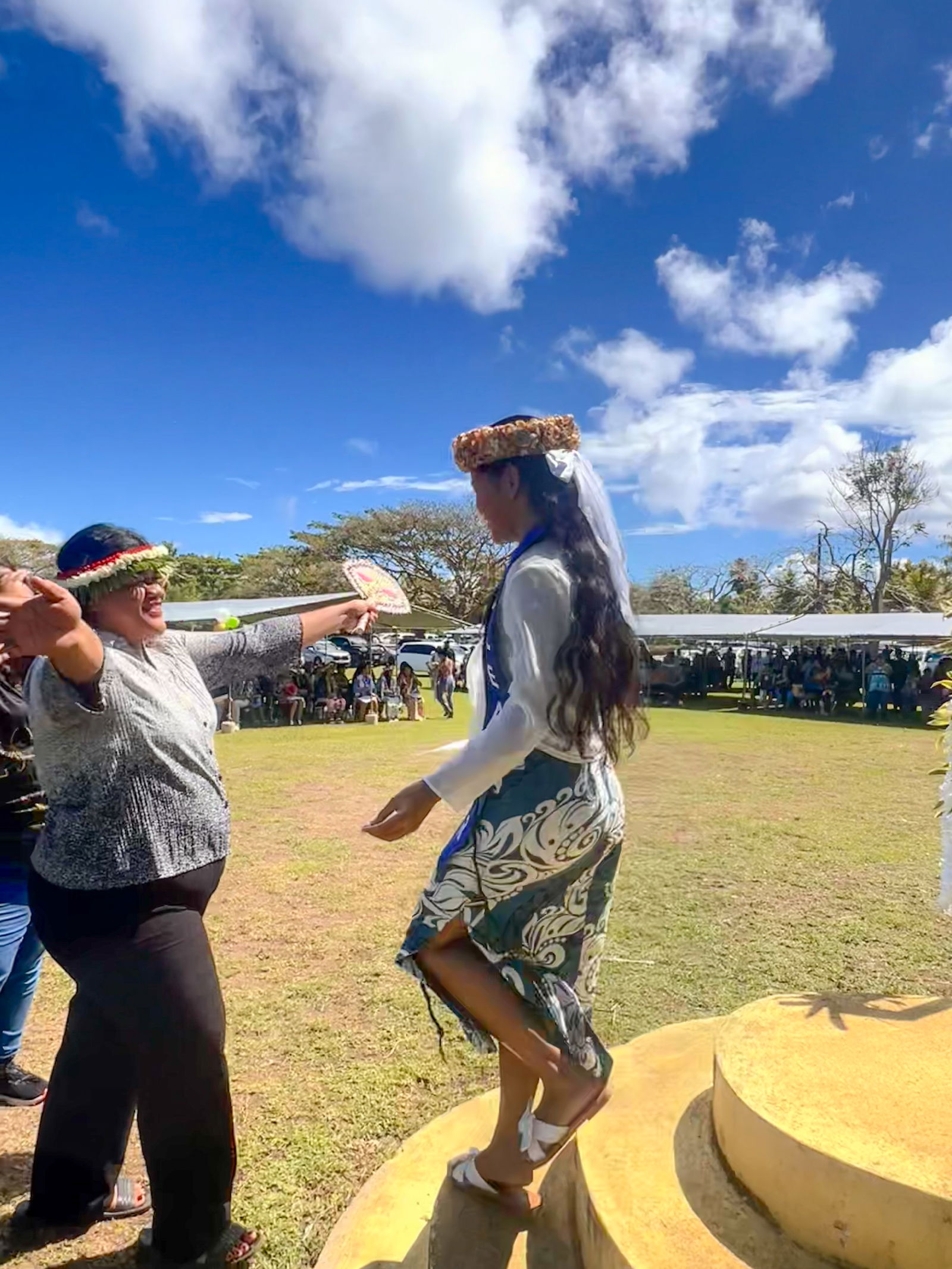 A classroom teacher excitedly congratulates a promoted student.