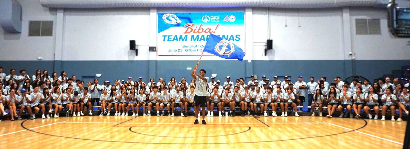 Team Marianas’ flag bearer, Isaiah Aleksenko, waves the CNMI flag during the send-off ceremony hosted by the Northern Marianas Sports Association at the Ada gym on Monday evening.Photo by James F. Sablan Jr.