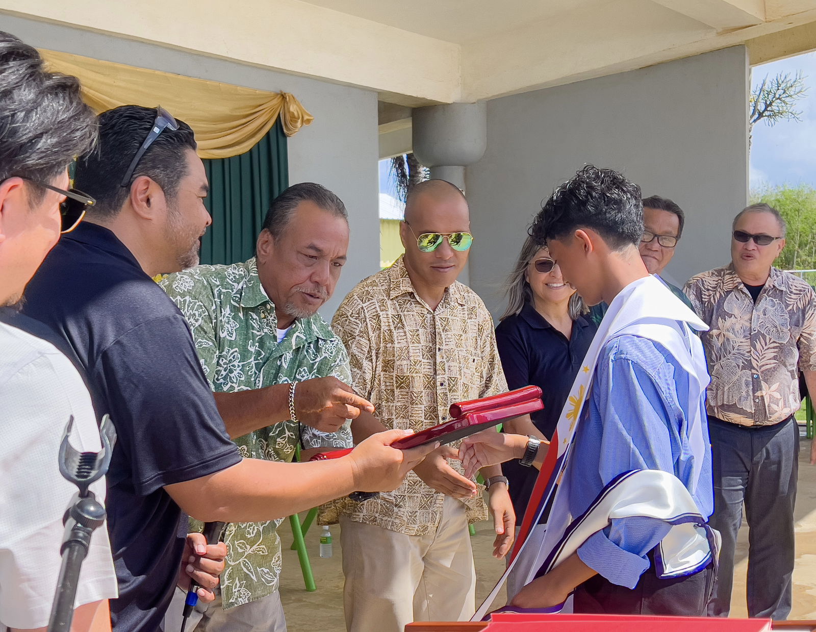 Board of Education Chairman Aschumar Kodep Ogumoro-Uludong, BOE Vice Chairman Anthony DLC Barcinas, BOE Member Andrew L. Orsini and Teacher Representative Dr. Dora Miura congratulate Dandan Middle School class valedictorian and recipient of the BOE Academic Excellence Award, Clyde Manangan. Also in photo are DMS Vice Principal Reo Arriola, Sen. Ronnie Calvo and Saipan Major RB Camacho. 