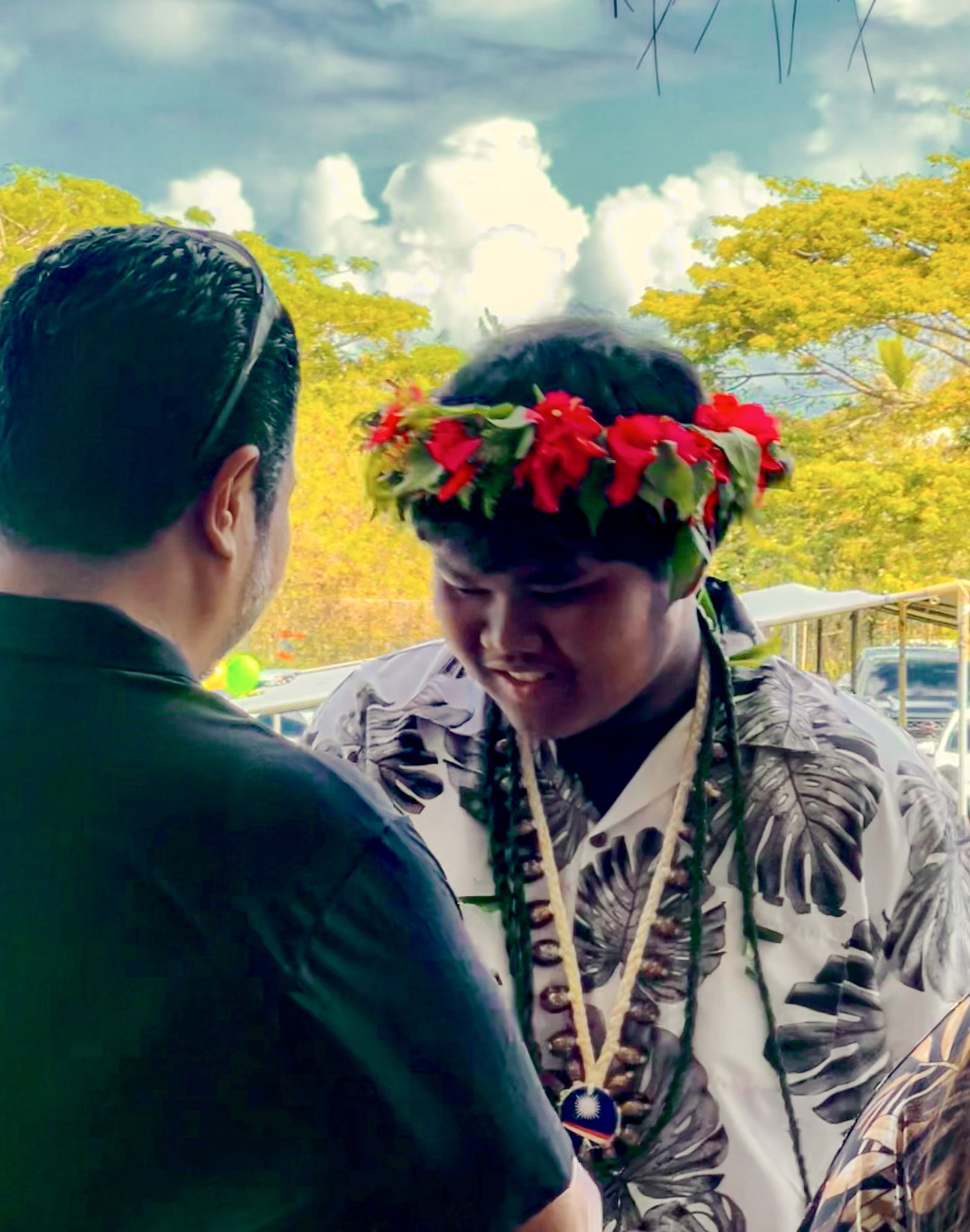 BOE Chairman Aschumar Kodep Ogumoro-Uludong congratulates a promoted student.