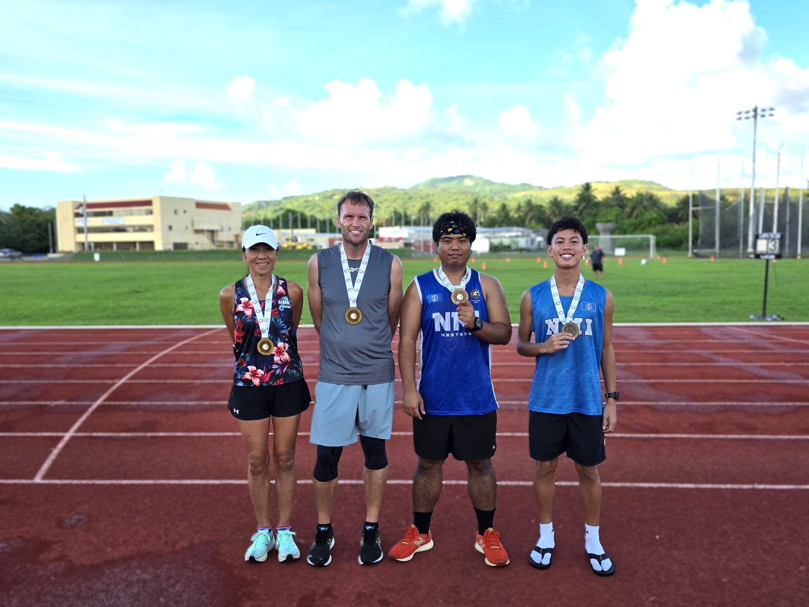 5000m gold medalists Akiko Miller (W55), Chad Taflinger (M40), Simon Necesito (M35), and Nash Santos (U18) pose with their gold medals during the awards ceremony of the Northern Marianas Athletics Masters Athletics Championships on Thursday at Oleai Sports Complex.Photo by James F. Sablan Jr.