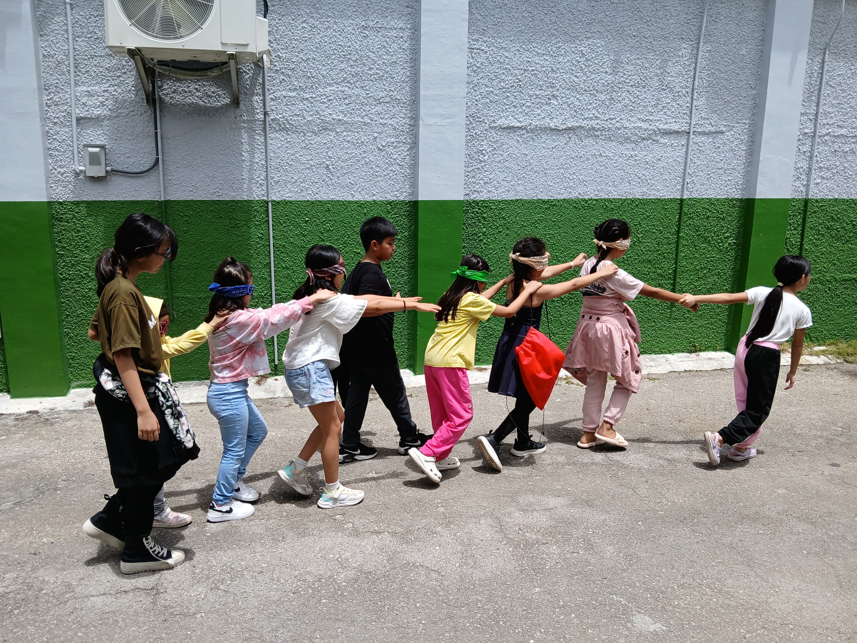 Energetic campers participate in a Trust Walk activity guided by their team leaders.