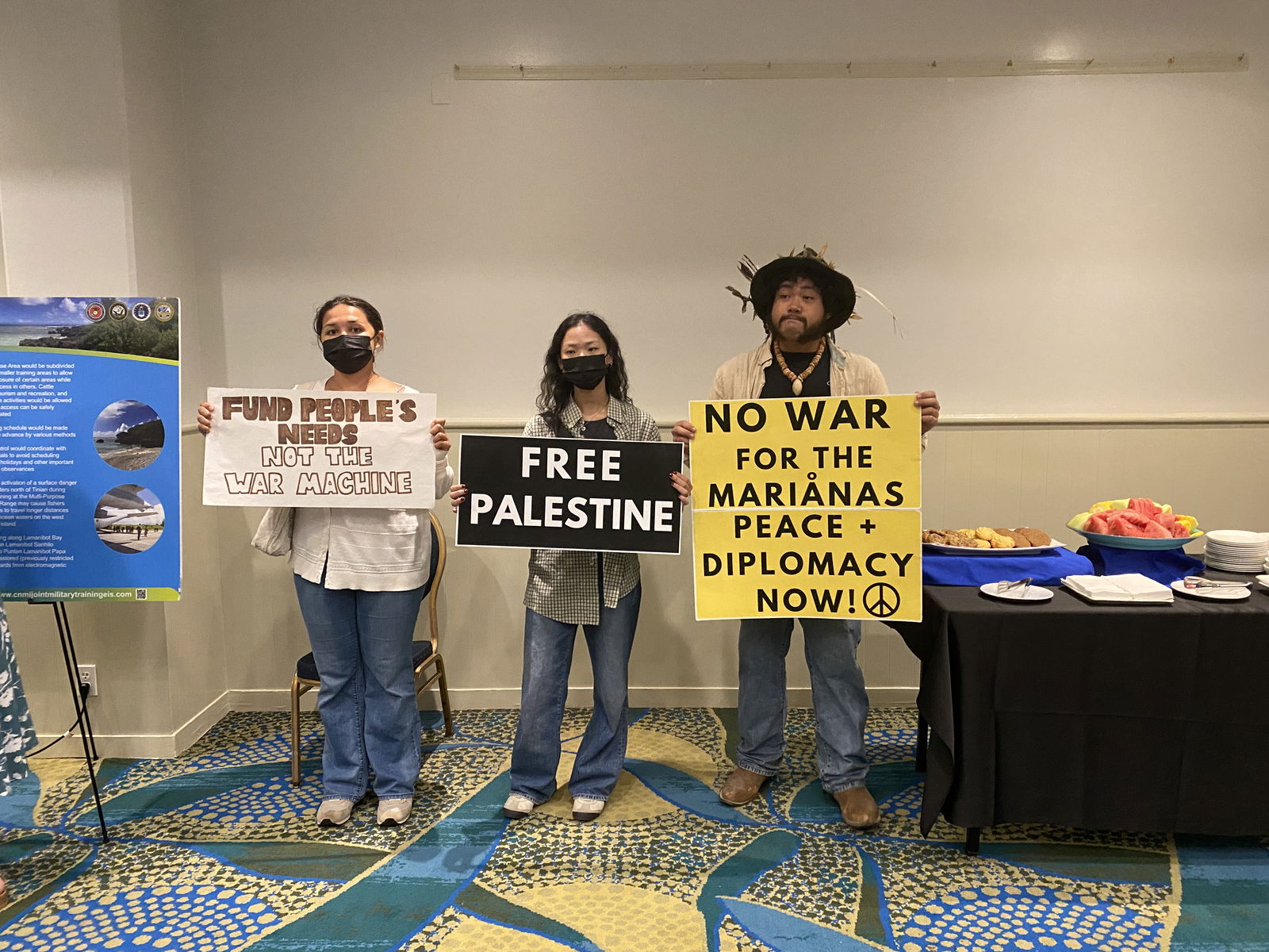 Anufat Pangelinan, right, protests the militarization of the CNMI.