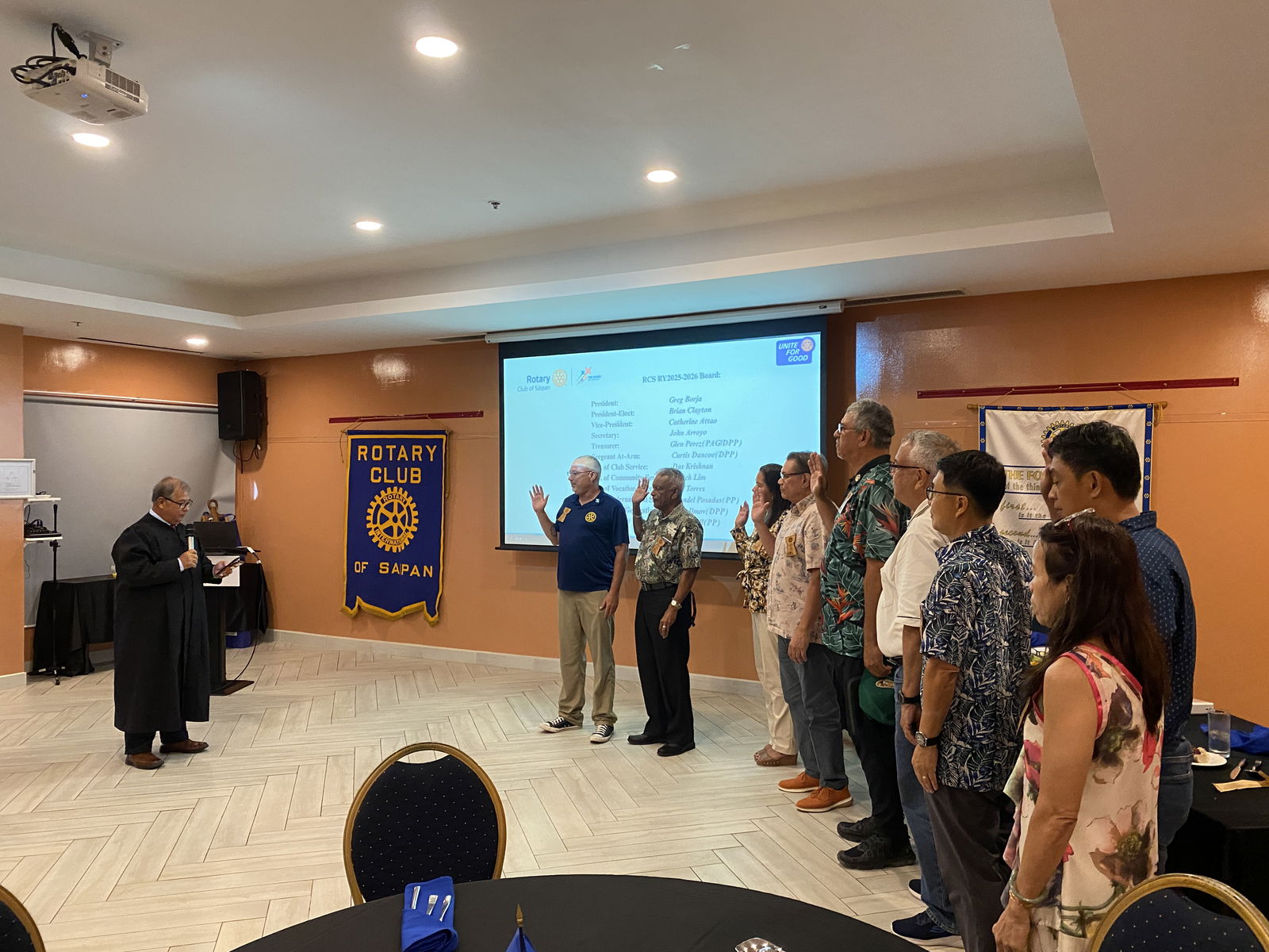 Justice Perry Inos, left, swears in the new officers of the Rotary Club of Saipan.