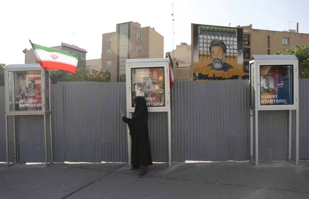 A woman stands on a street, amid the Iran-Israel conflict, in Tehran, Iran, June 23, 2025.Majid Asgaripour/West Asia News Agency via REUTERS