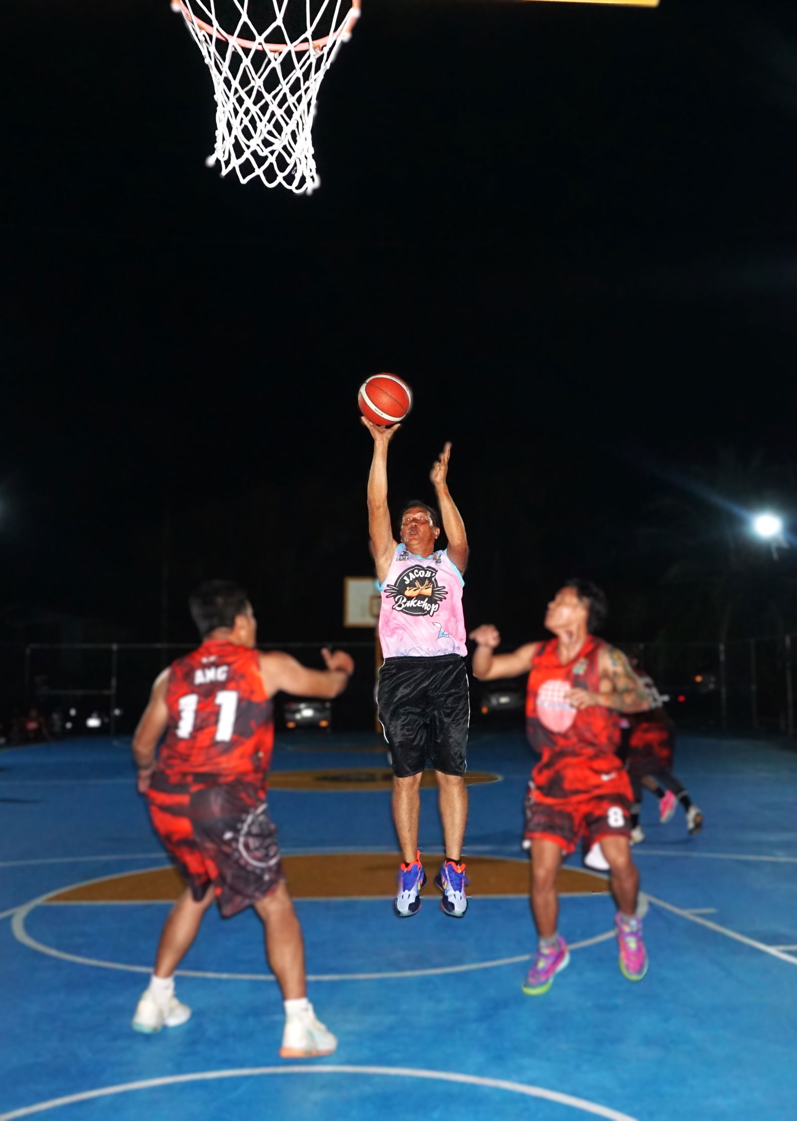 Jacob's Alex Ocampo extends for the close range shot between two defenders during a game against Seabridge in the B Division of the E-Sports CNMI Invitational Basketball League 2025 at the Gualo Rai basketball court on Saturday.Photo by James F. Sablan Jr.