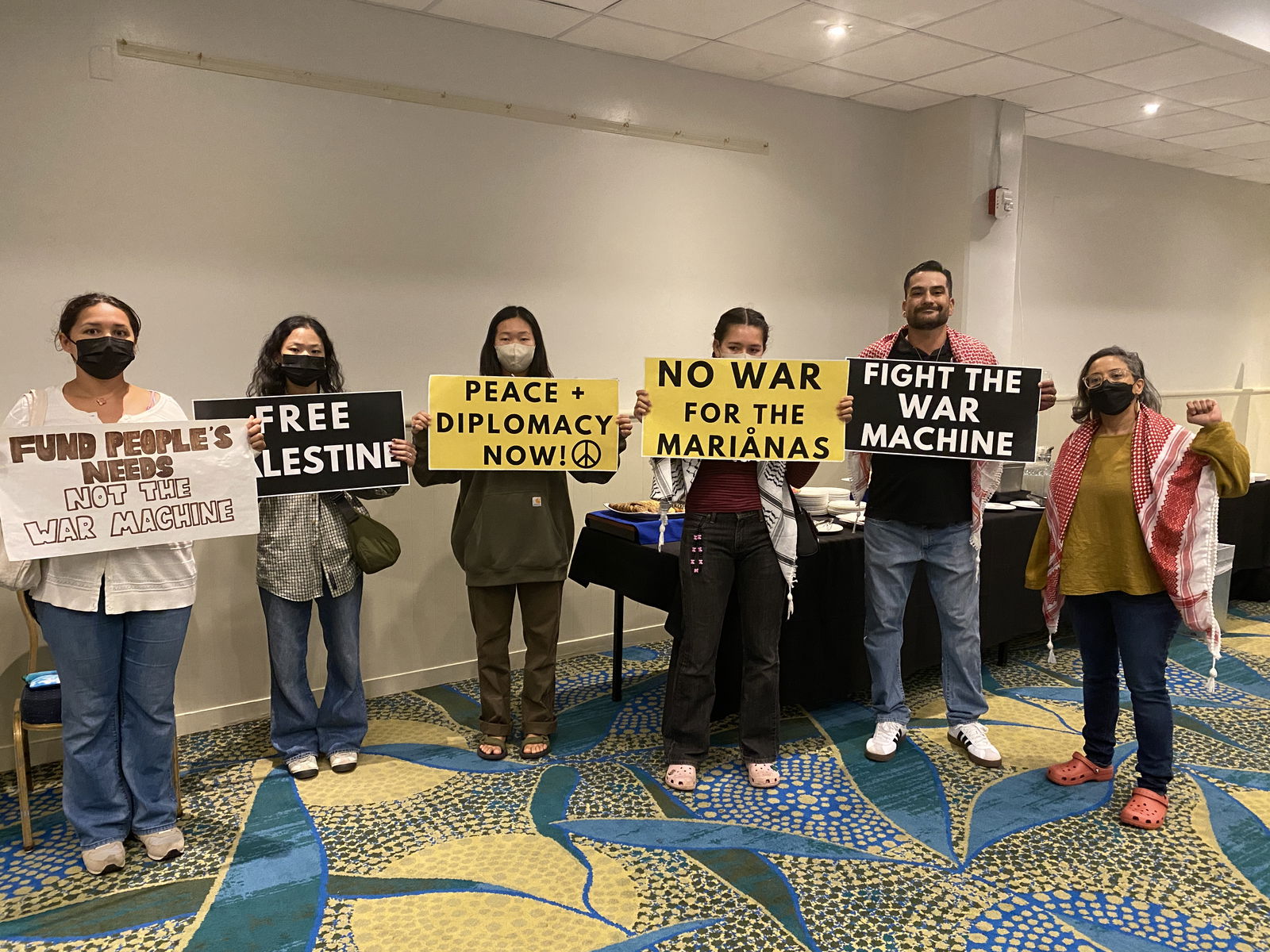 Island residents hold posters and silently protested militarization in the Marianas and Palestine.
