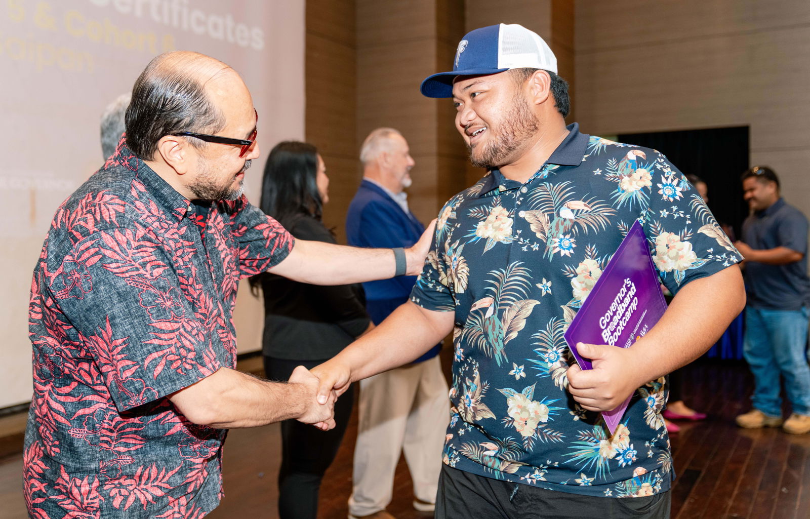 Northern Marianas College President Galvin Deleon Guerrero, EdD, shakes hands with a graduate of the Governor’s Broadband Bootcamp on Saturday, June 14, 2025. The 19-week program was facilitated through a partnership between the Office of the Governor’s Broadband Policy and Development Program, Northern Marianas College's Center for Training and Innovation, NMTech, Island Training Solutions and the CNMI Department of Labor. NMC photo