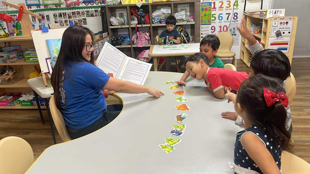 K4 students listen enthusiastically to the story Kate the Chameleon during story time.