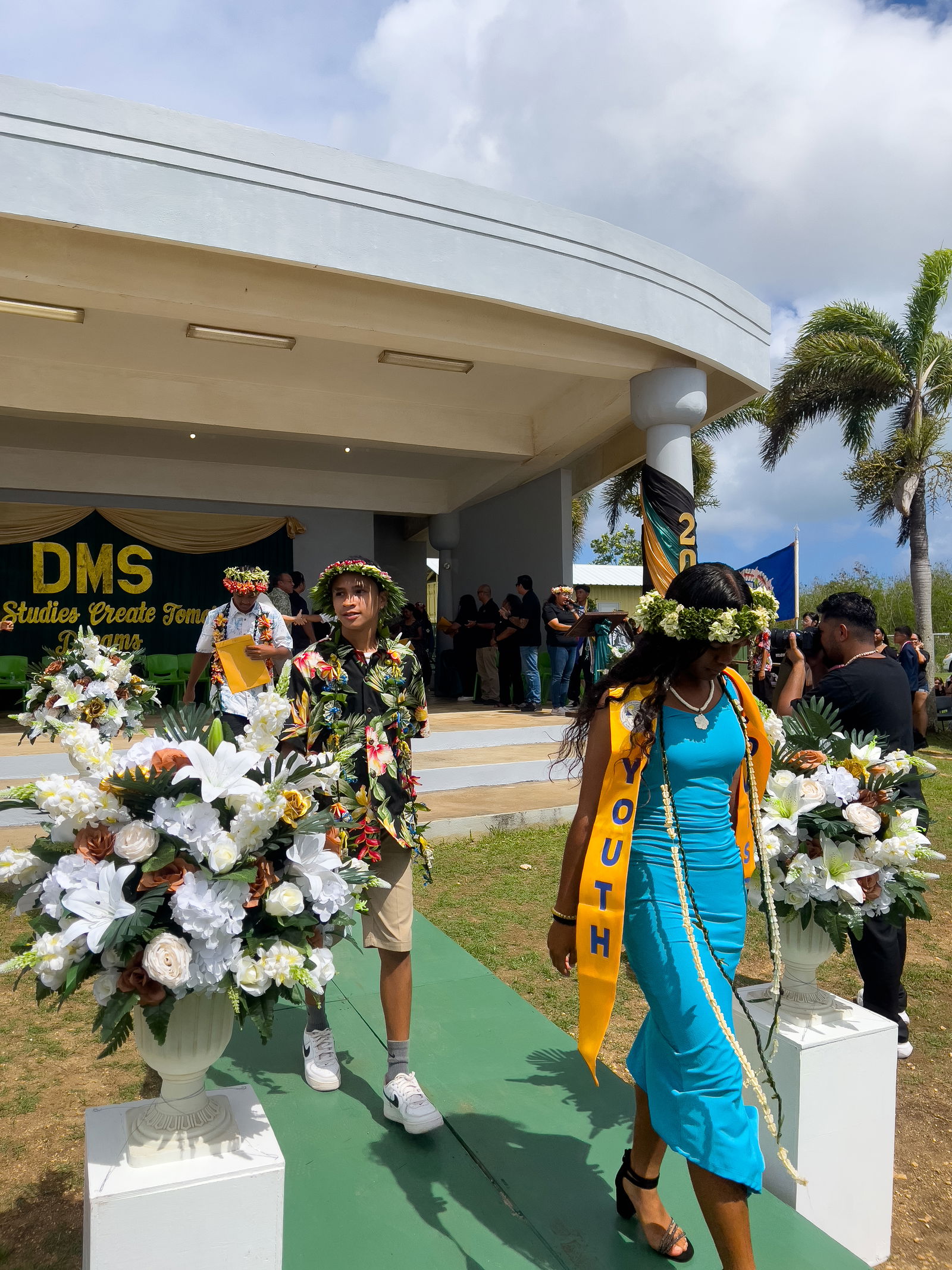 Promoted students return to their seats after receiving their certificates.