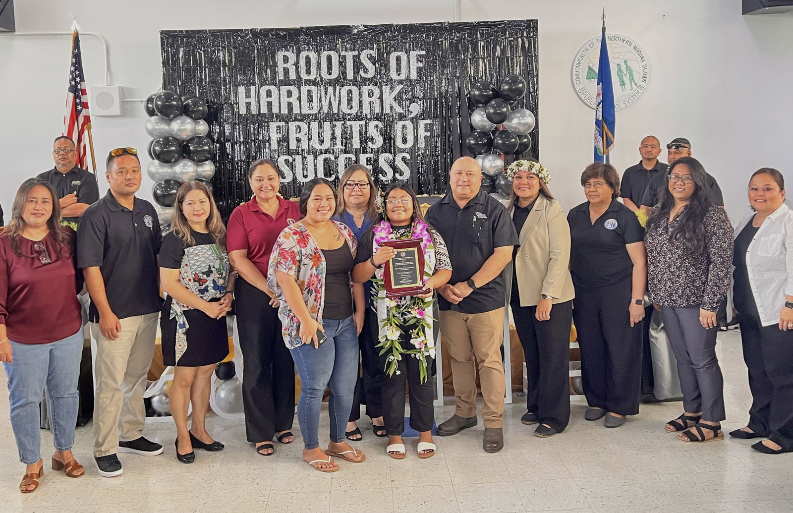 Class salutatorian Tini Monette Sablan Wabol, center, with Commissioner of Education Dr. Lawrence F. Camacho, other PSS officials and COVMS administrators.