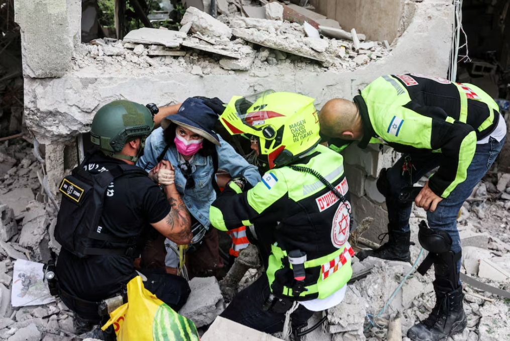 Rescue personnel evacuate a resident from under a building at an impacted site after a missile attack from Iran, amid the Iran-Israel conflict in Tel Aviv, Israel on June 22, 2025.REUTERS