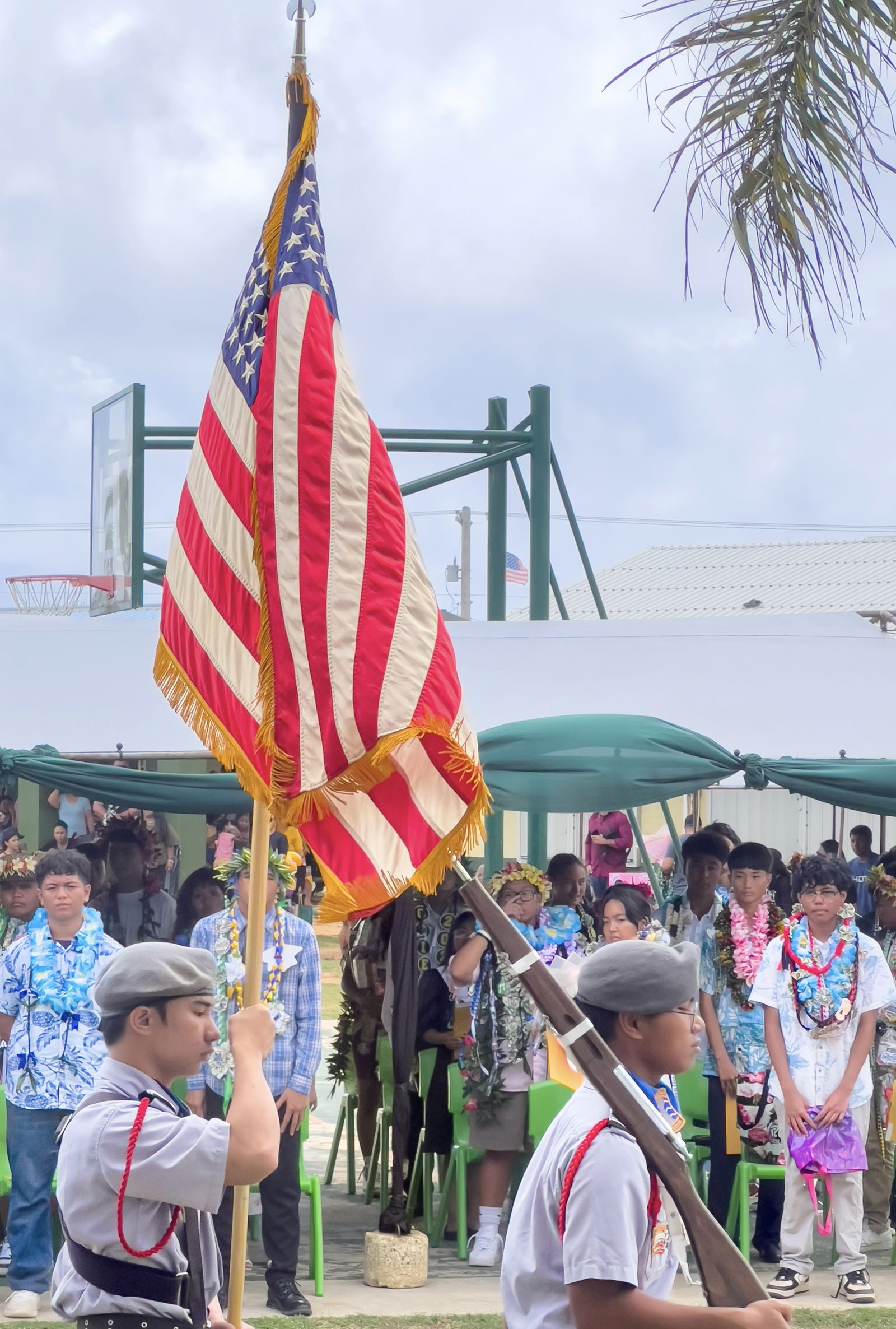 Promoted students stand at attention as JROTC cadets retire the colors.