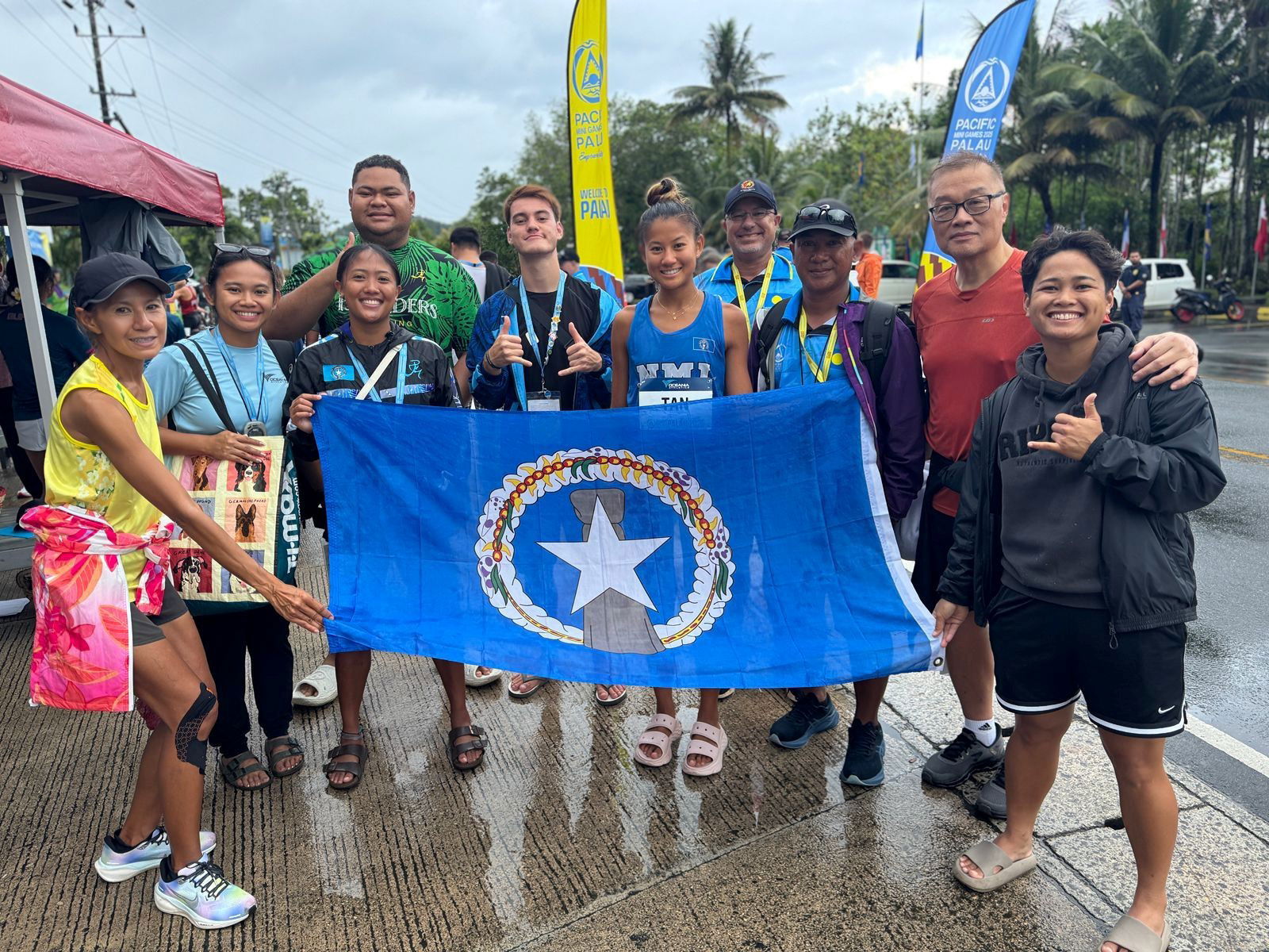Fellow athletes, coaches, family members, and team officials show their support to Pacific Mini Games gold medalist Tania Tan, sixth left, after she completed the half marathon race in Palau last week.